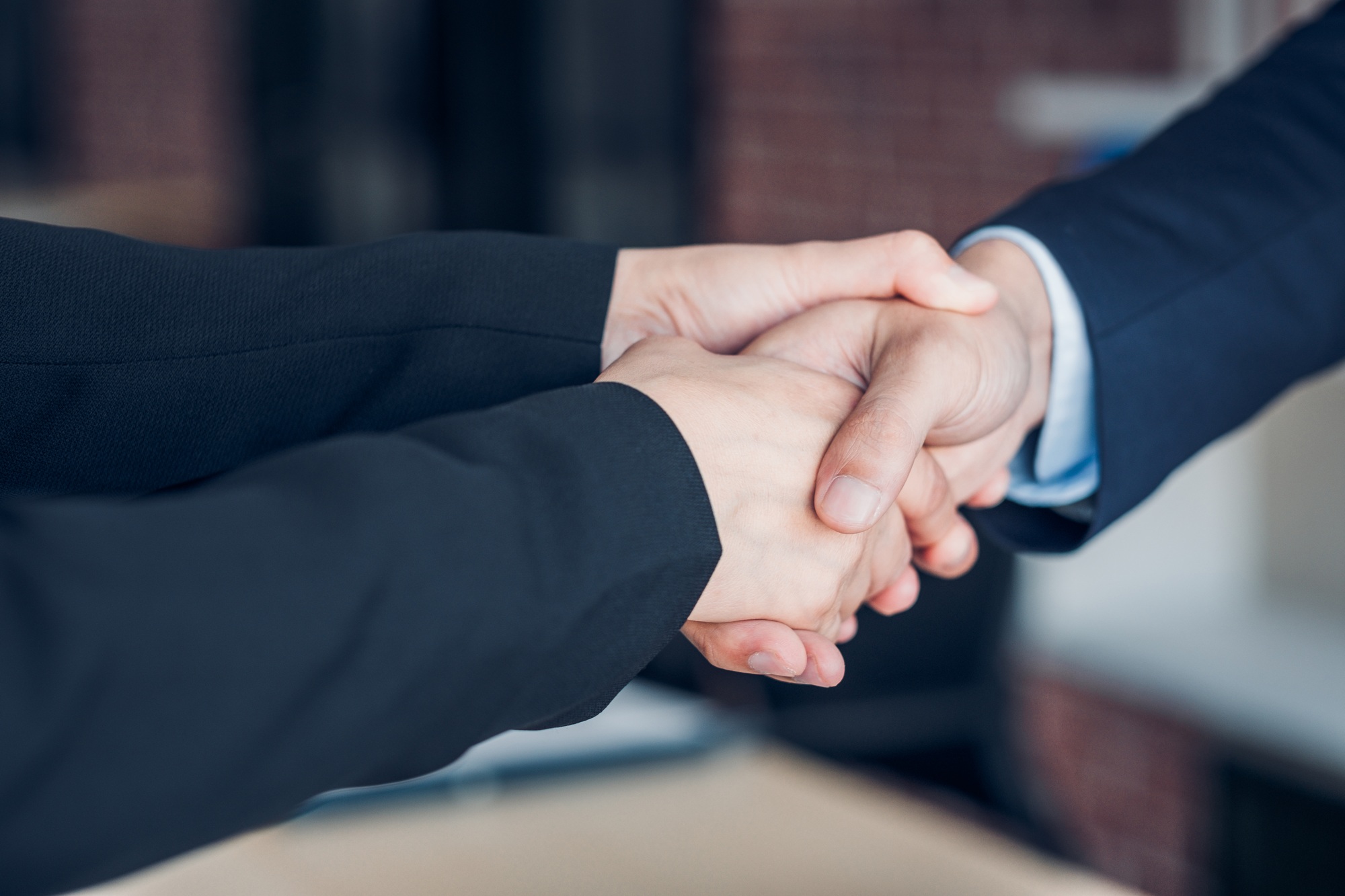 Close up two handshake between businesswoman and businessman at meeting