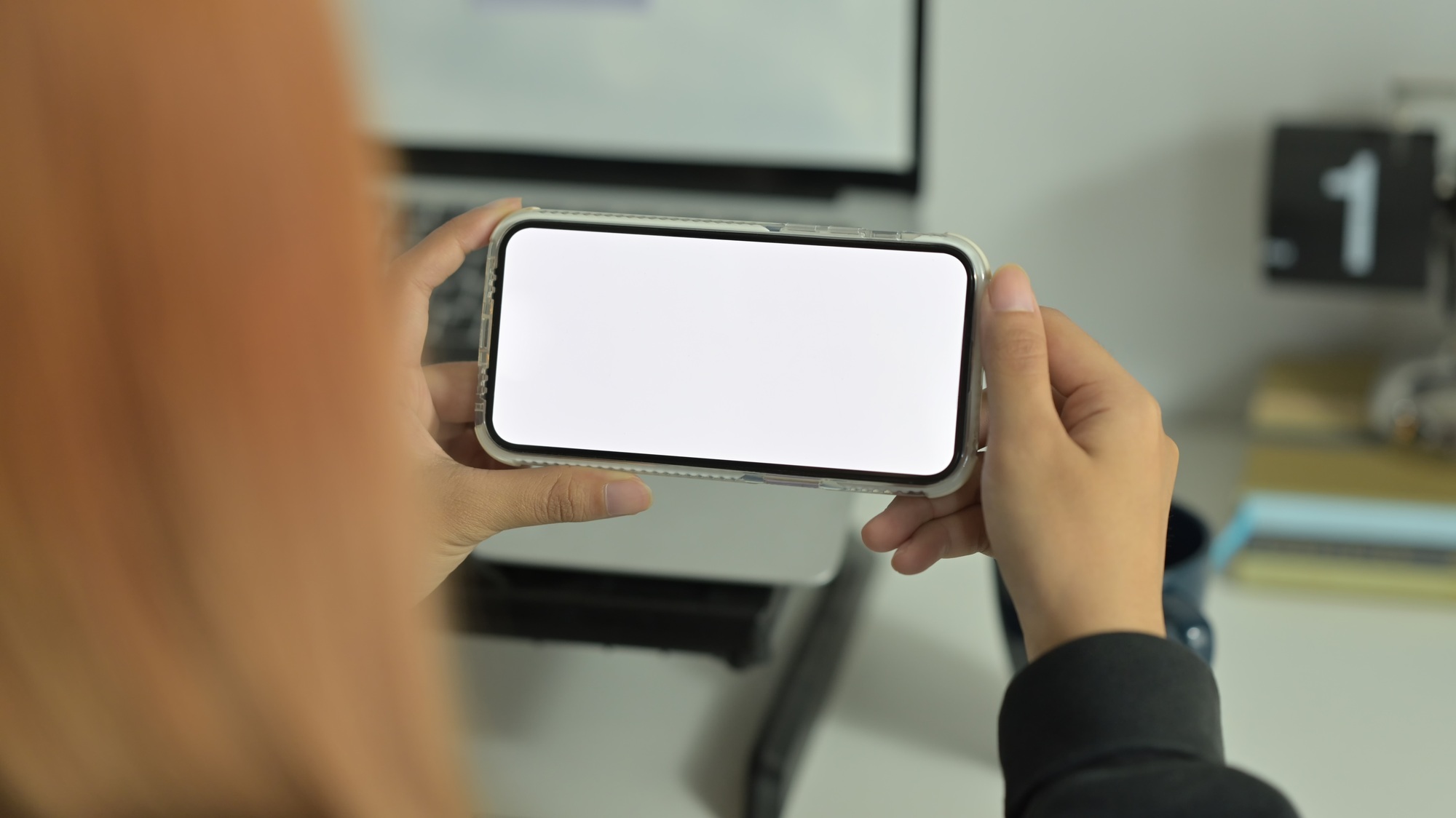 Close up view of young woman hands holding smart phone in horizontal position.