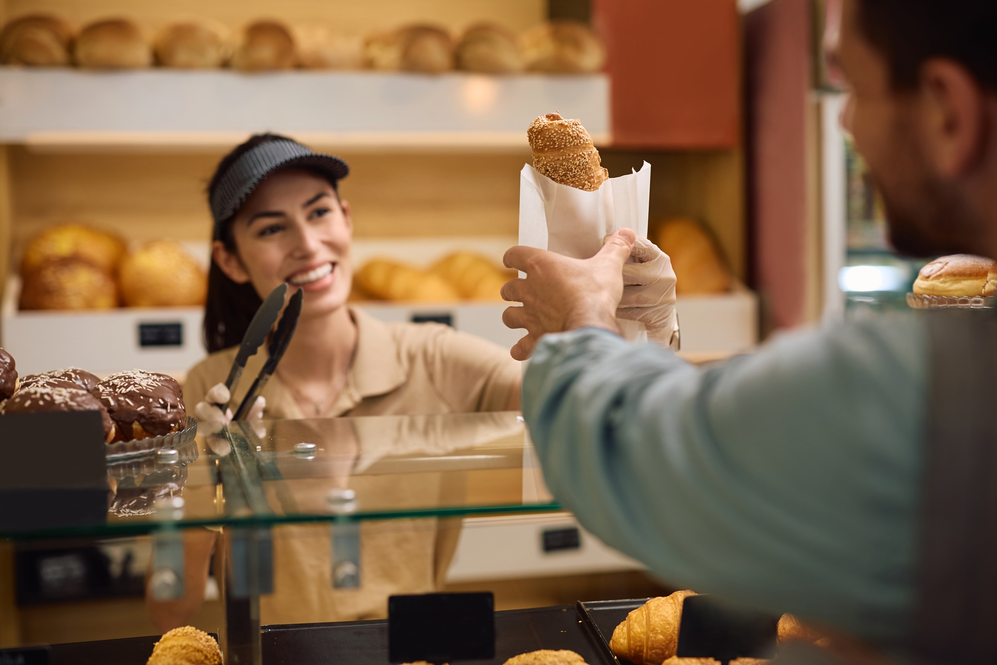 Close up worker serving a customer in a bakery.
