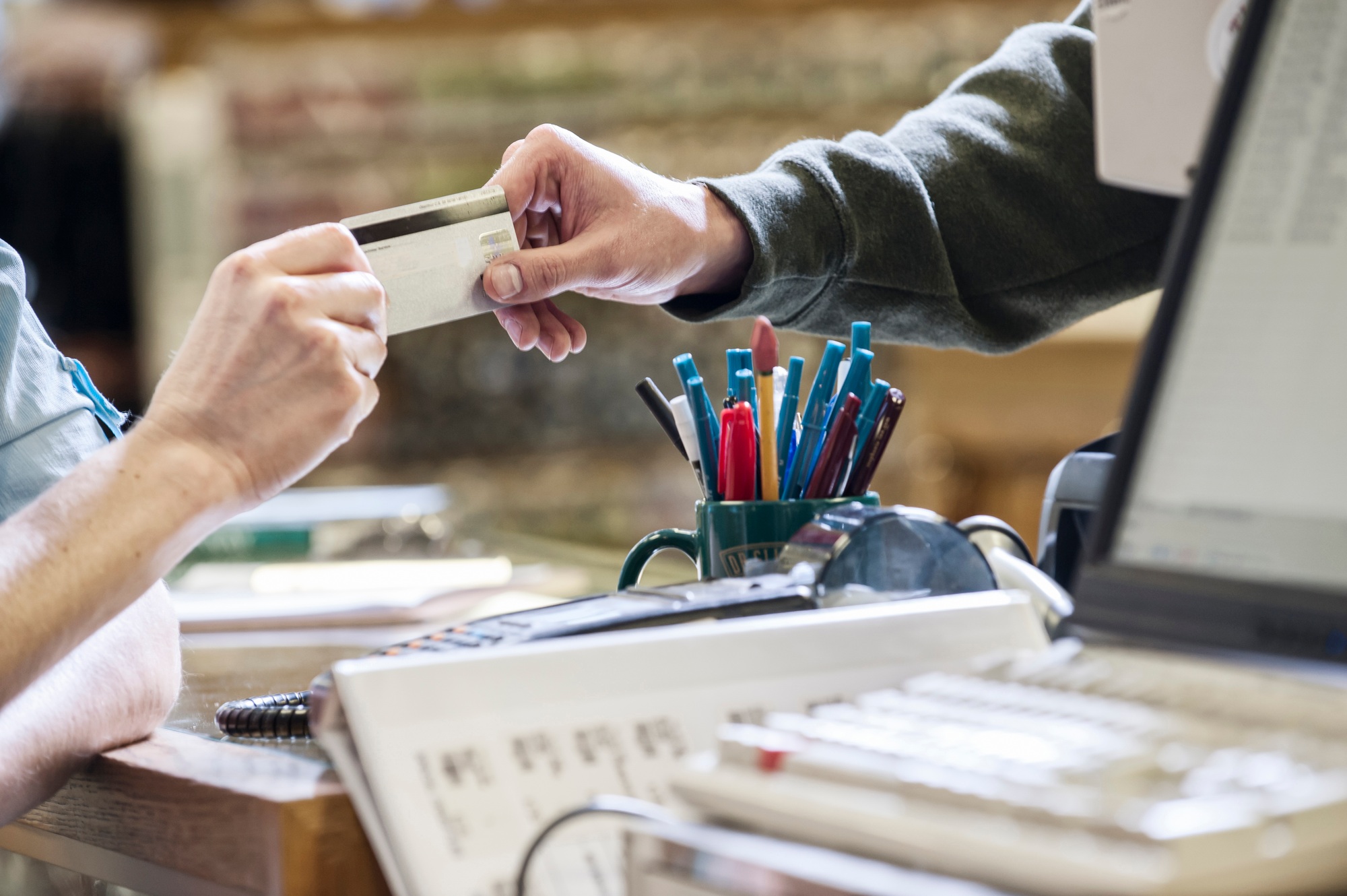 Closeup of hands exchanging a credit card during a retail sale