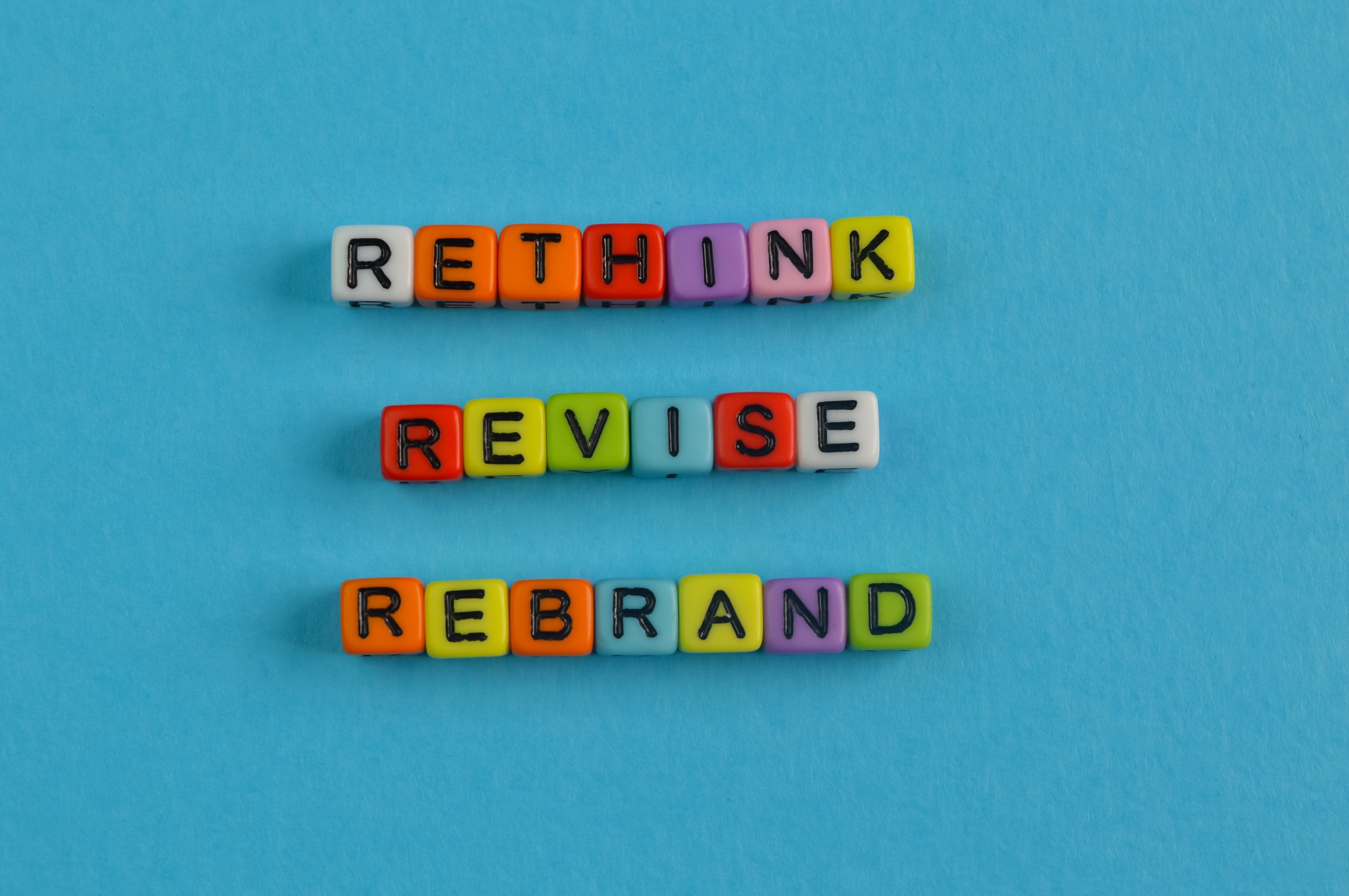 Colorful alphabet beads with text RETHINK, REVISE and REBRAND