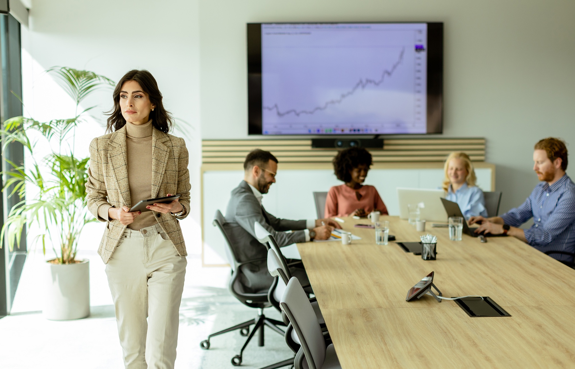 Confident businesswoman leading a strategic meeting in a modern office at midday