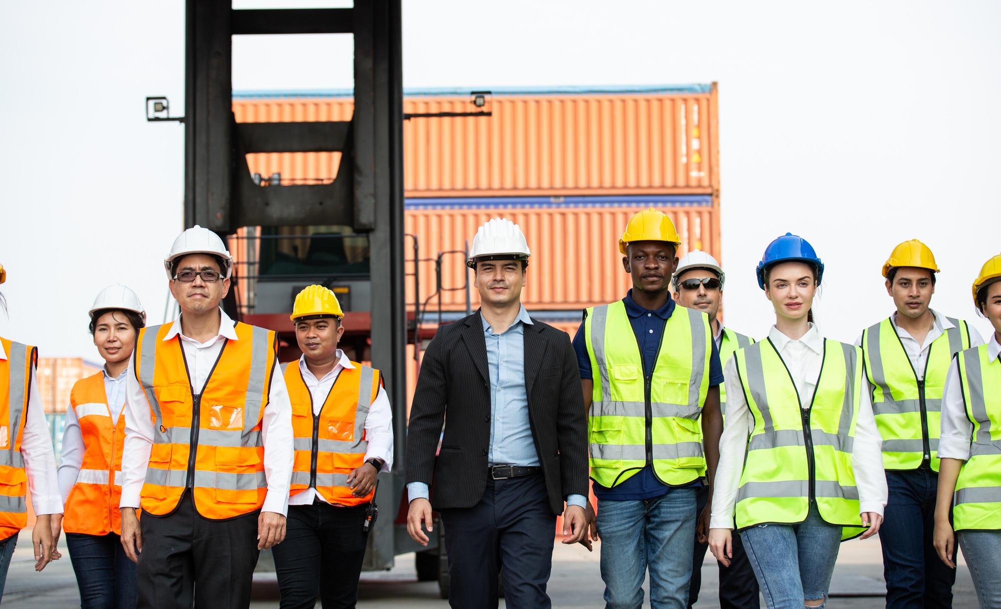 Corporate logistic team walking together at container warehouse
