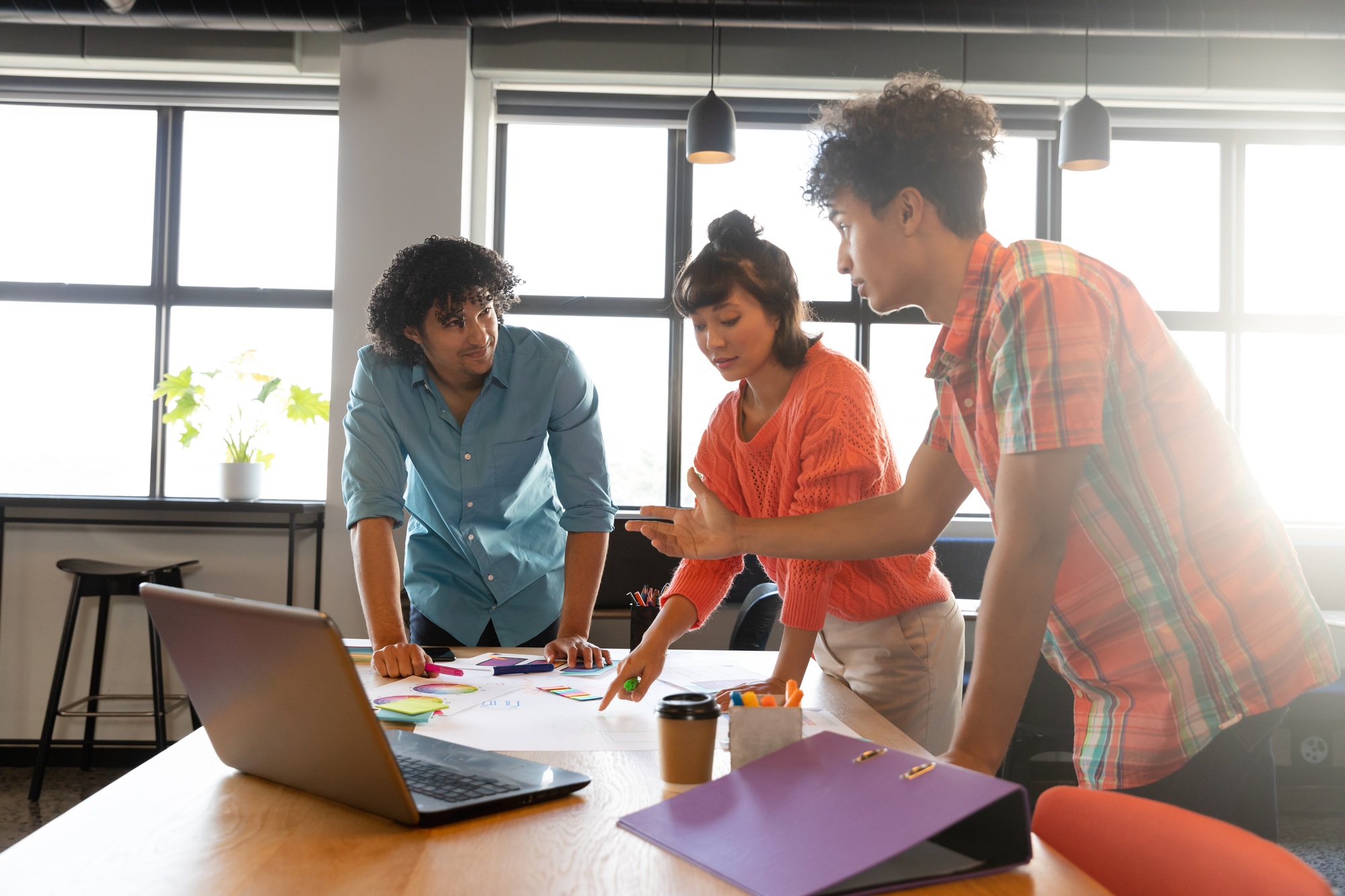 Creative multiracial design professionals planning strategy at table in office