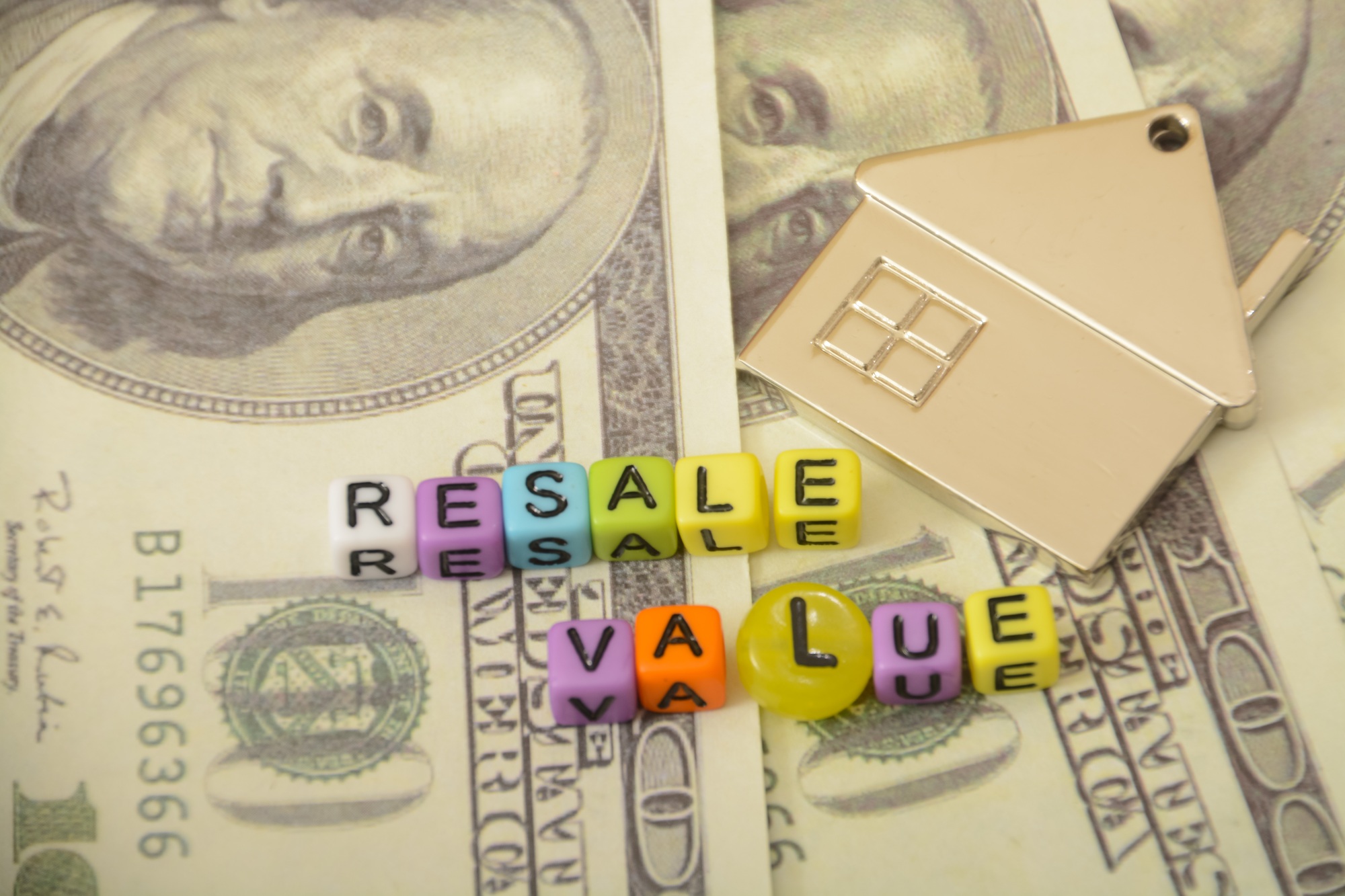 creatively home, money and arranged letters forming words related to the RESALE VALUE