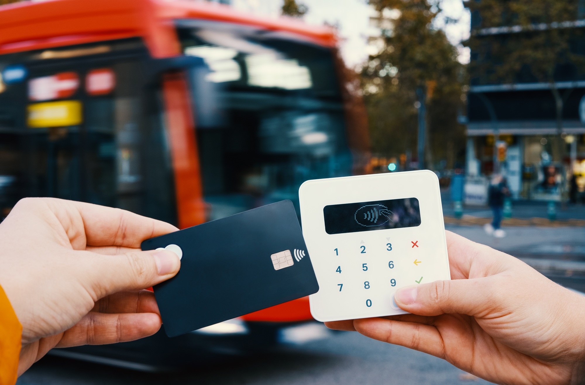Crop man paying for bus on POS terminal