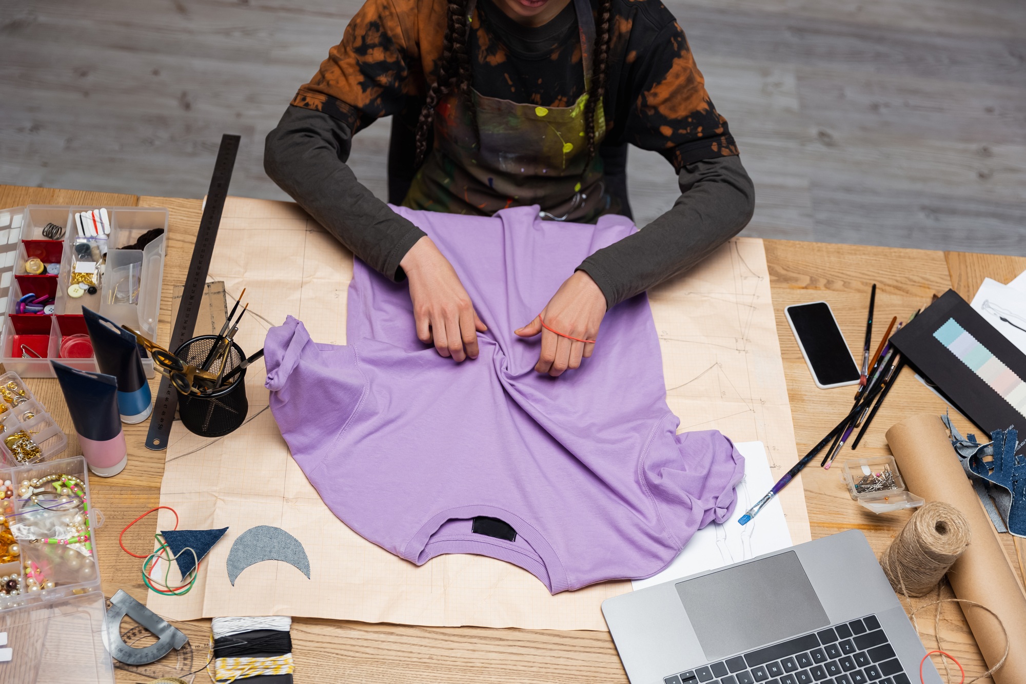 Cropped view of african american craftswoman working with t-shirt in workshop