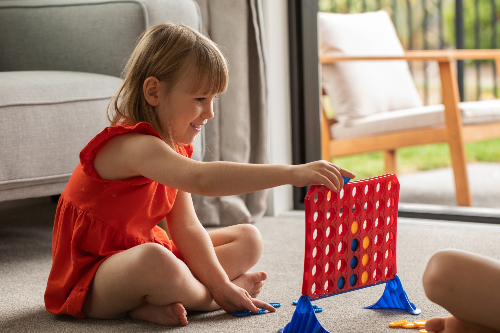 Cute little girl strategizing in Connect Four. Logic game