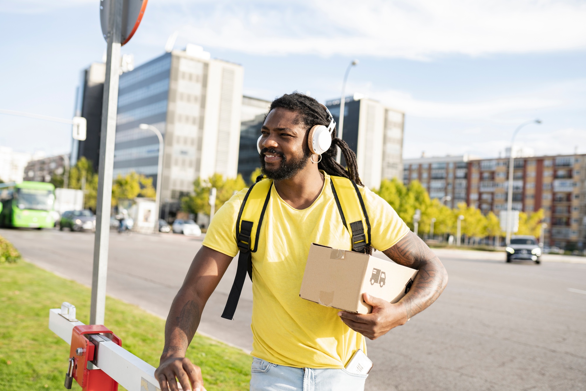 delivery man with backpack and package walking in the city