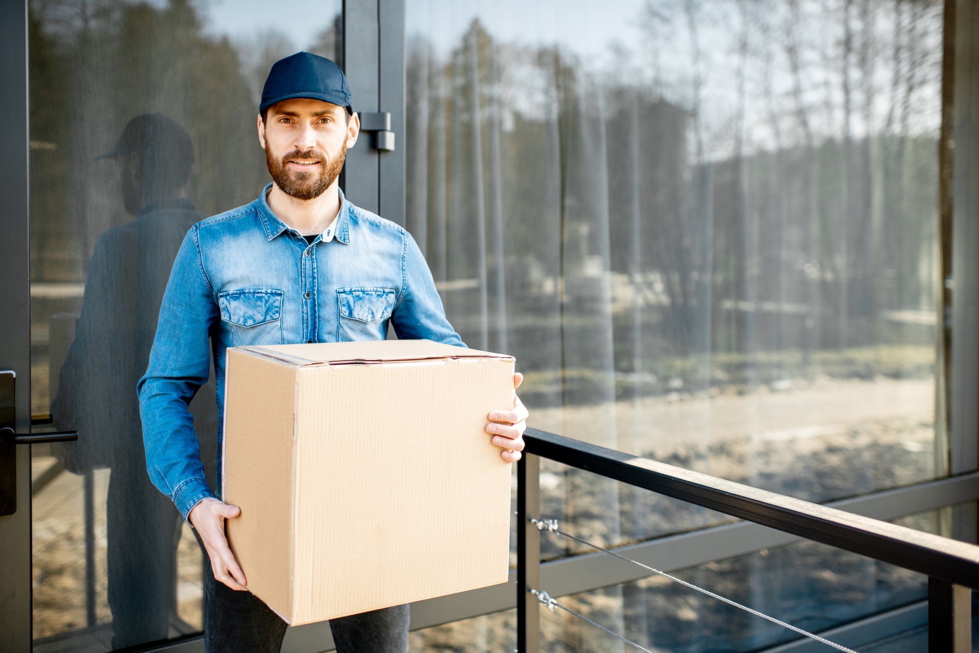 Delivery man with package near the house