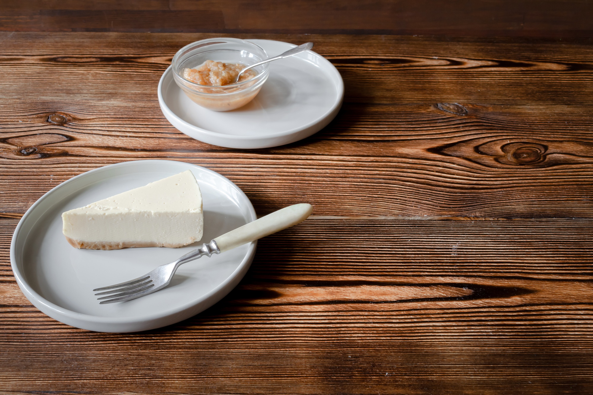 dessert classical cheesecake New York.Slice of cake on plate served with dessert fork and apple jam