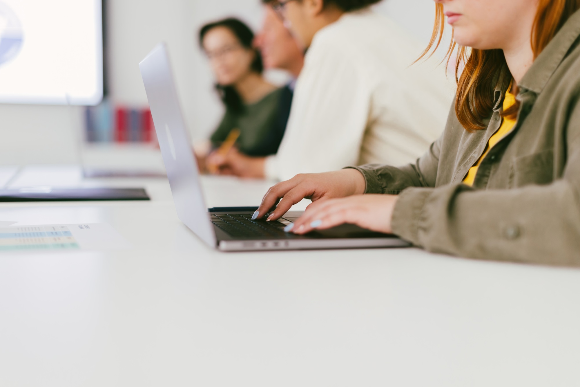 detail of the hand of a young office worker typing an email on the laptop