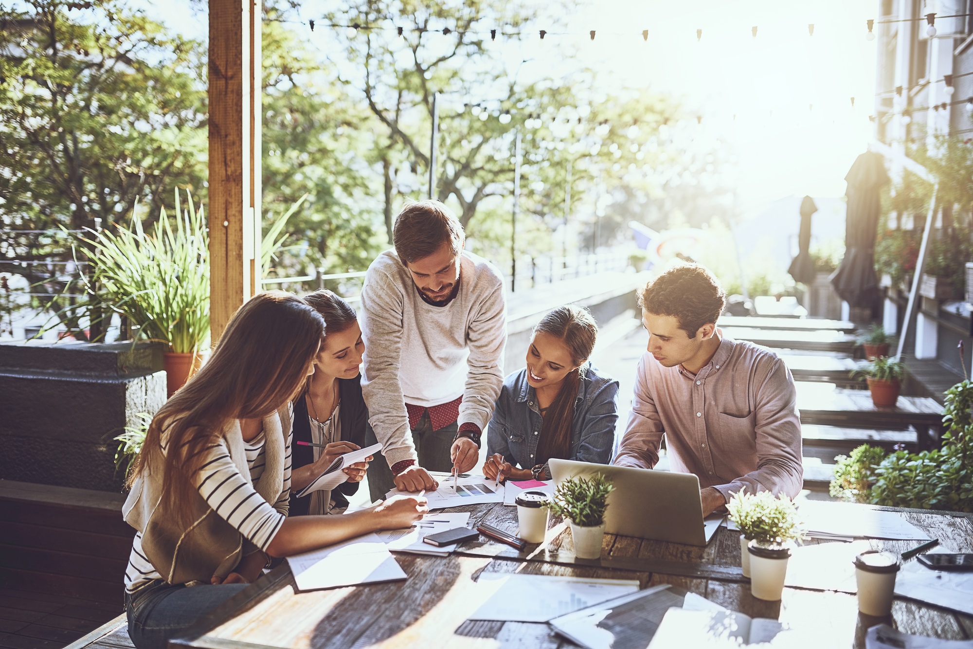 Different location, better productivity. Shot of a group of colleagues having a meeting at a cafe.