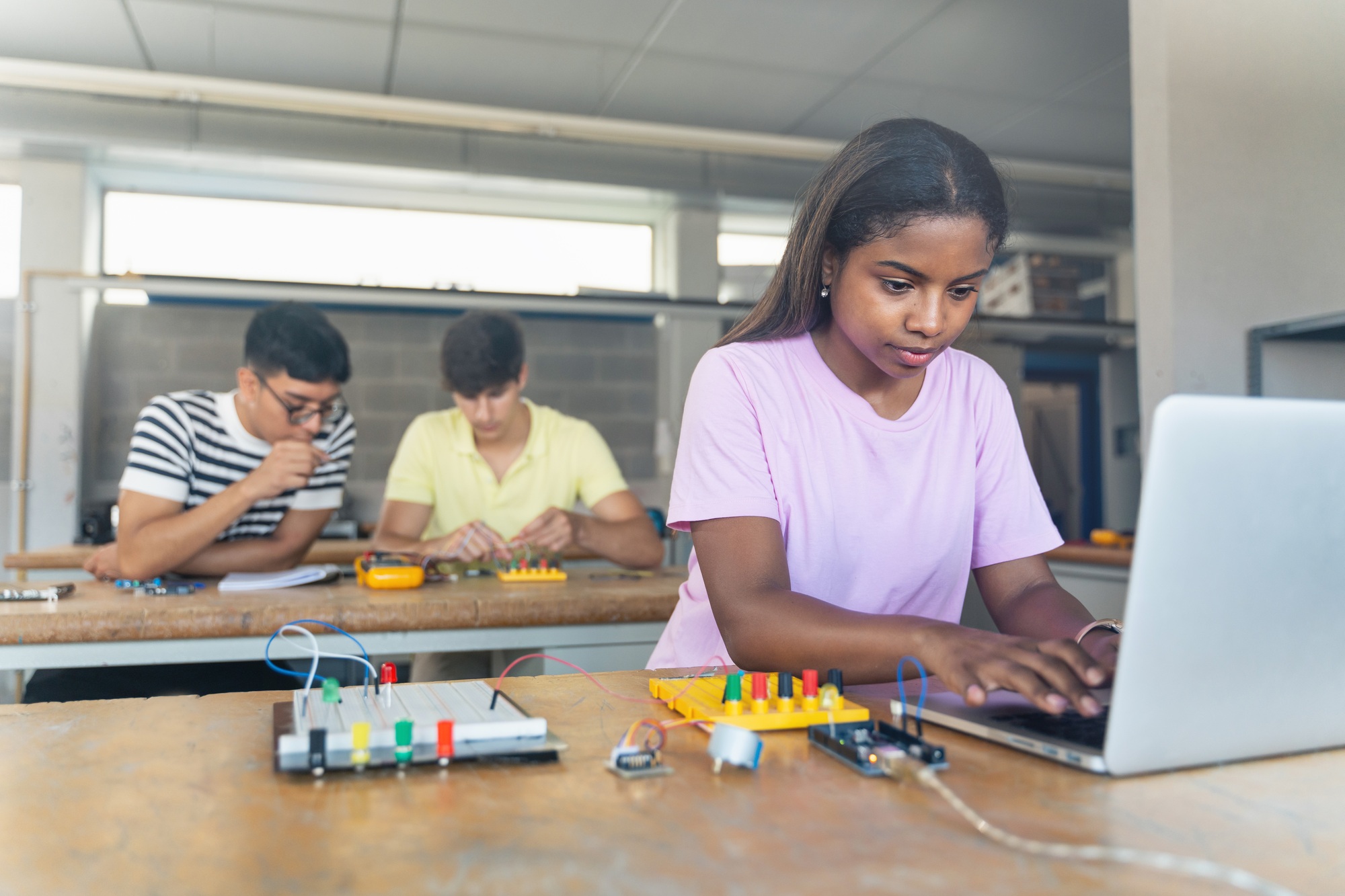 Digital InnovationAfrican American High School teenage Student programming electronics circuit board