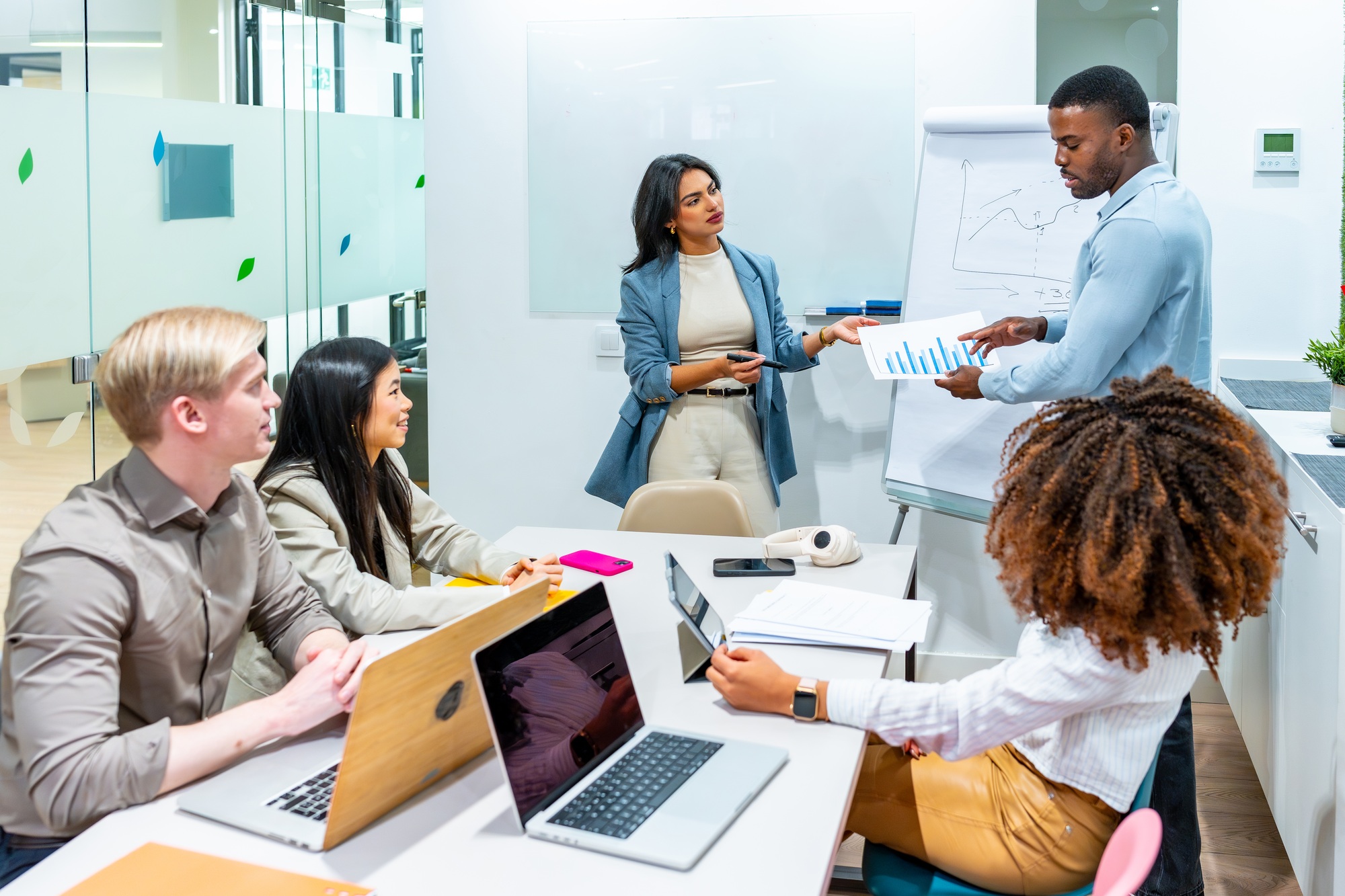 Diverse business team analyzing charts and growth strategies in modern office