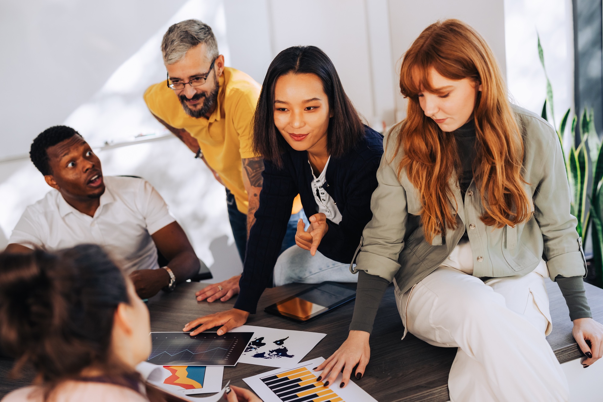 Diverse businesspeople at boardroom and analyzing charts and graphs.