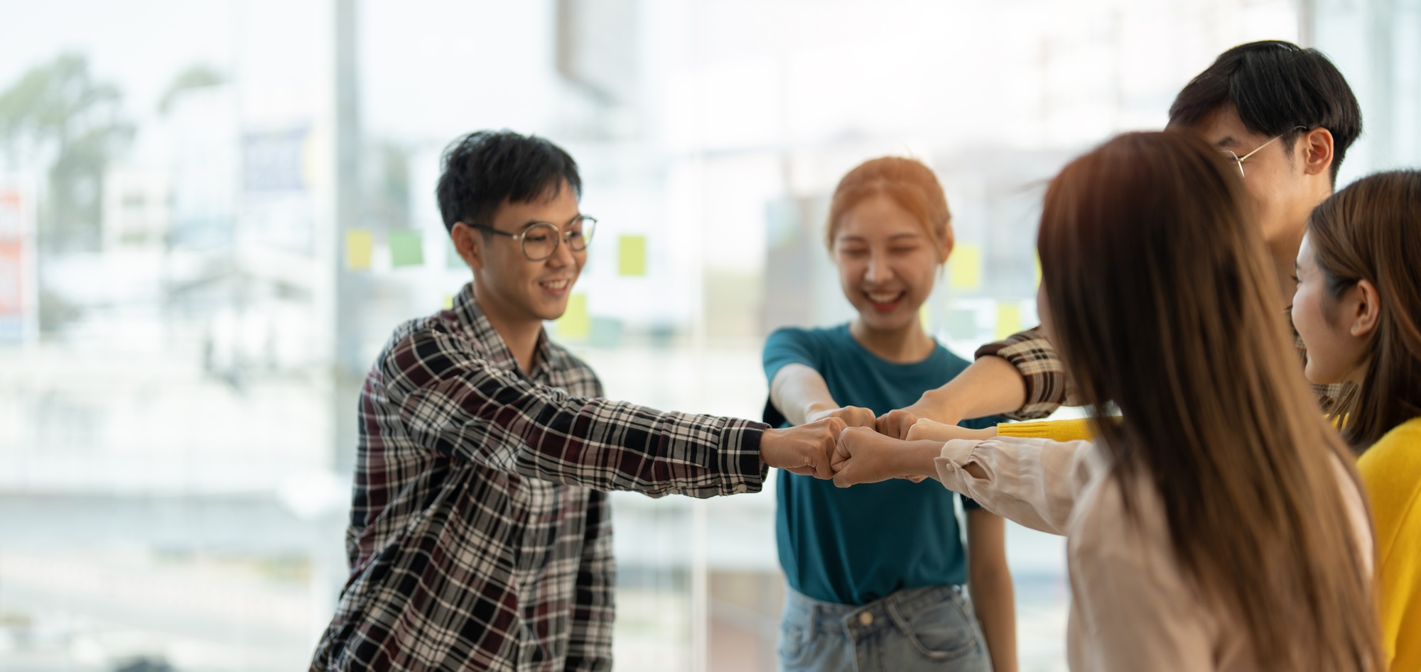 diverse group of asian business partner fist bump in modern office. Colleague partnership teamwork