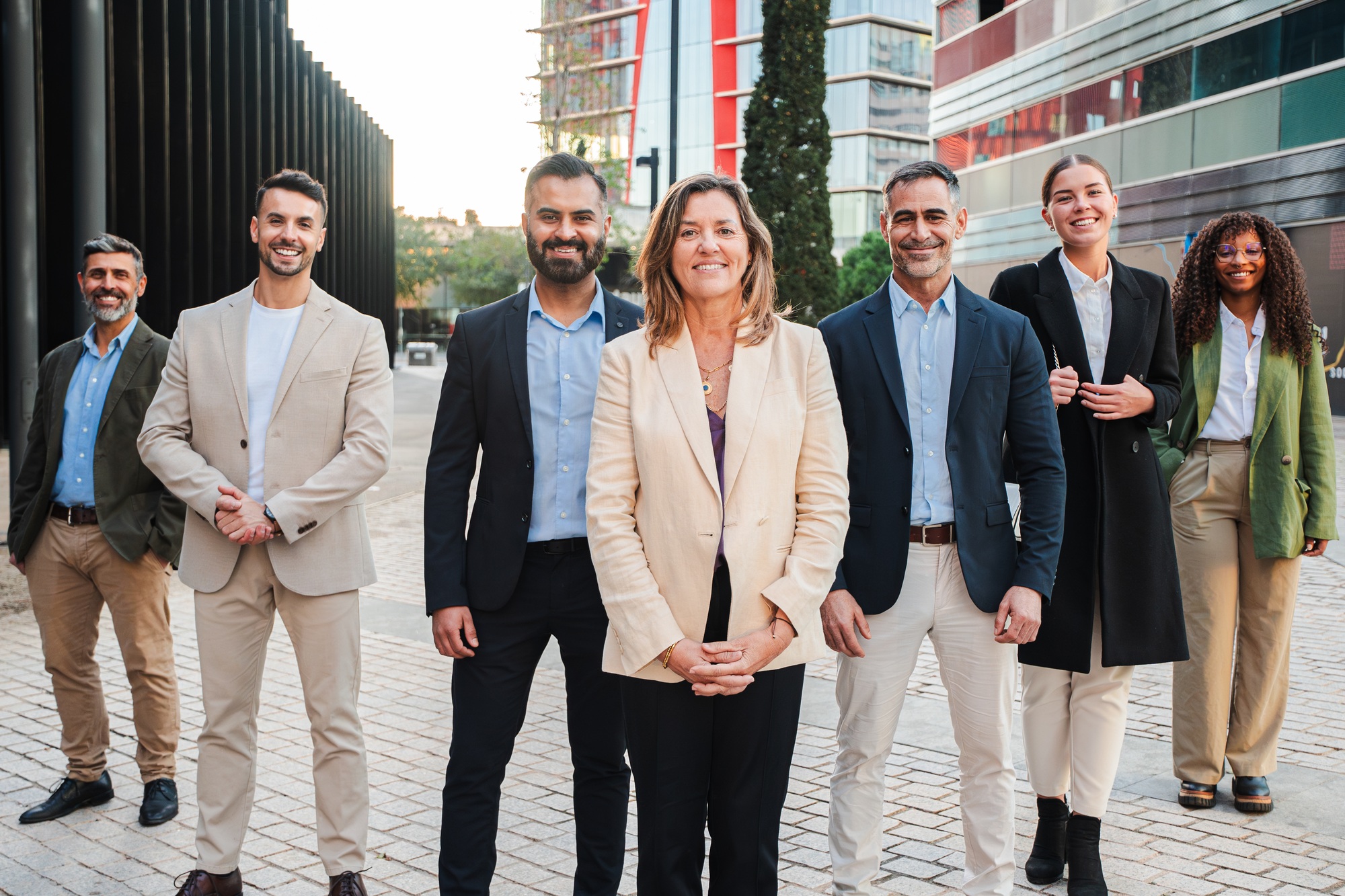Diverse Group of Professional Individuals Posing Together in Stylish Attire for a Corporate Portrait