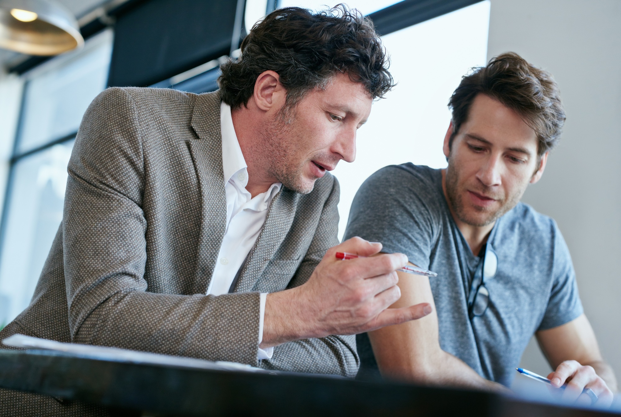 Doing a performance appraisal. Cropped shot of two handsome businessmen working in the office.
