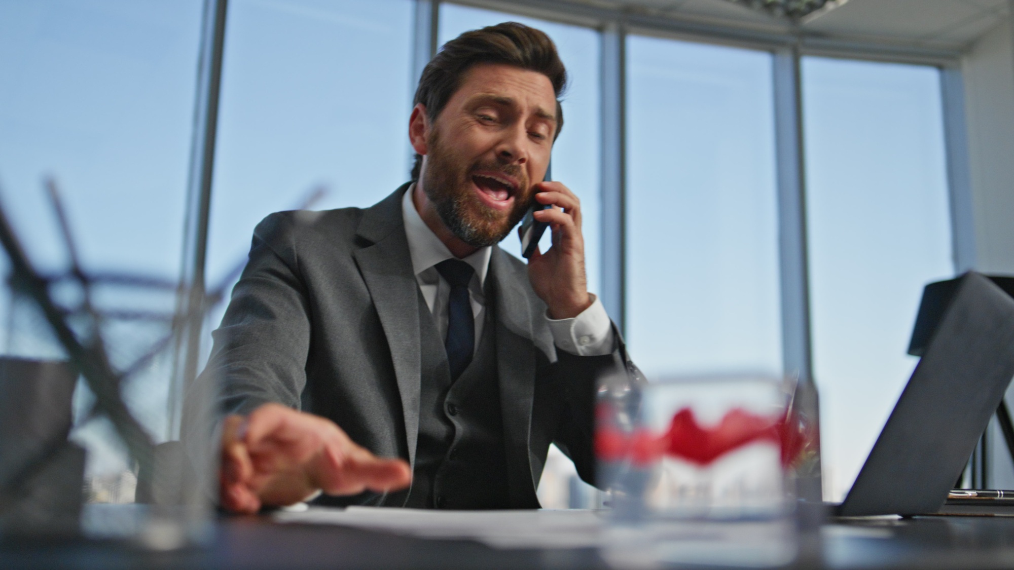 Emotional manager arguing smartphone conversation in modern office portrait.