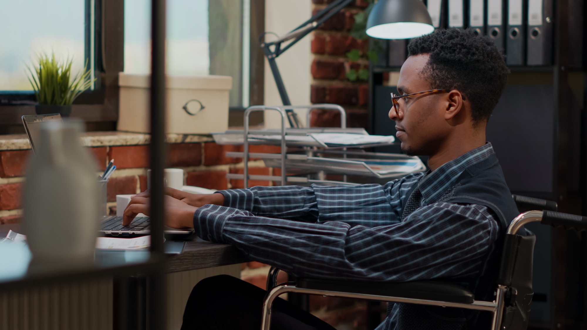 Employee with special needs working on laptop to plan strategy