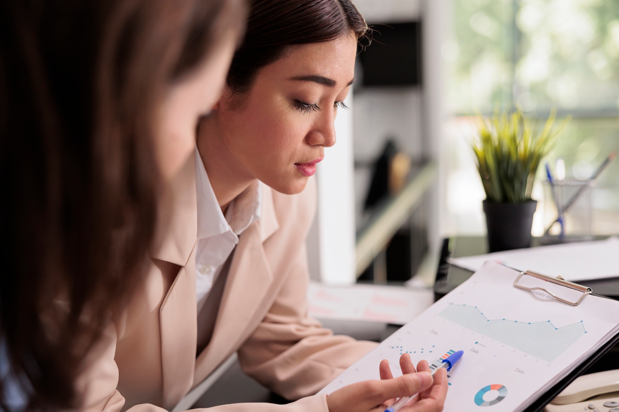Employees analyzing financial report statistics on clipboard