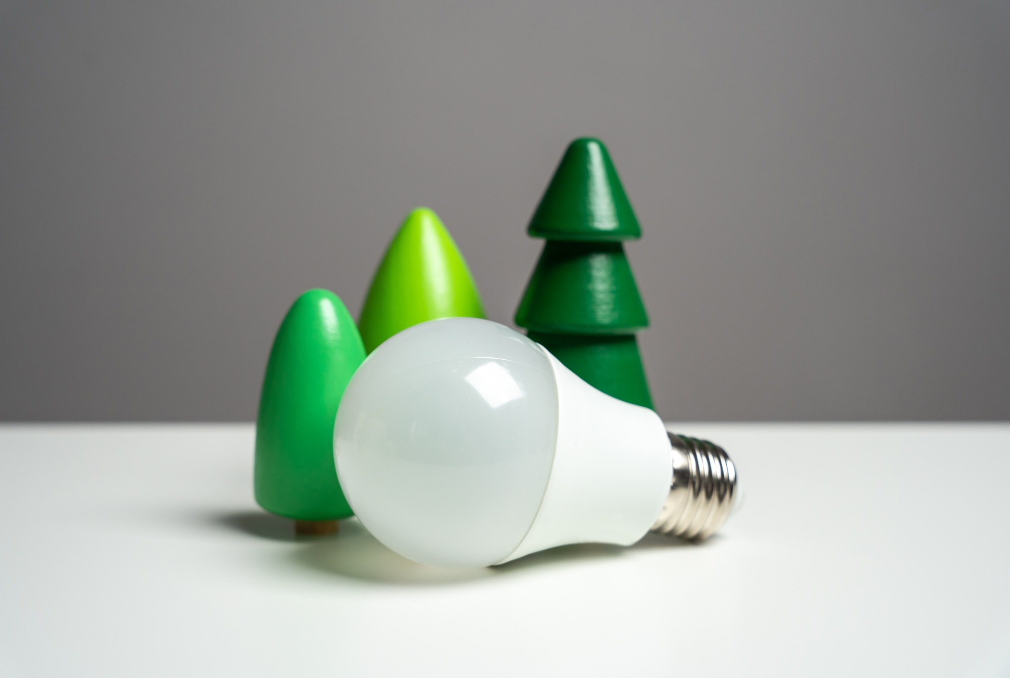 Energy saving light bulb surrounded by forest trees.