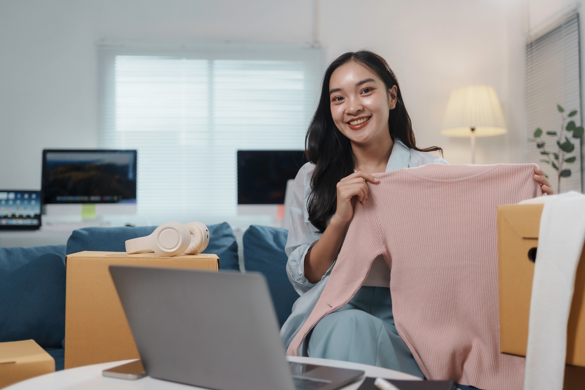 Entrepreneur showcasing clothing in online store setup