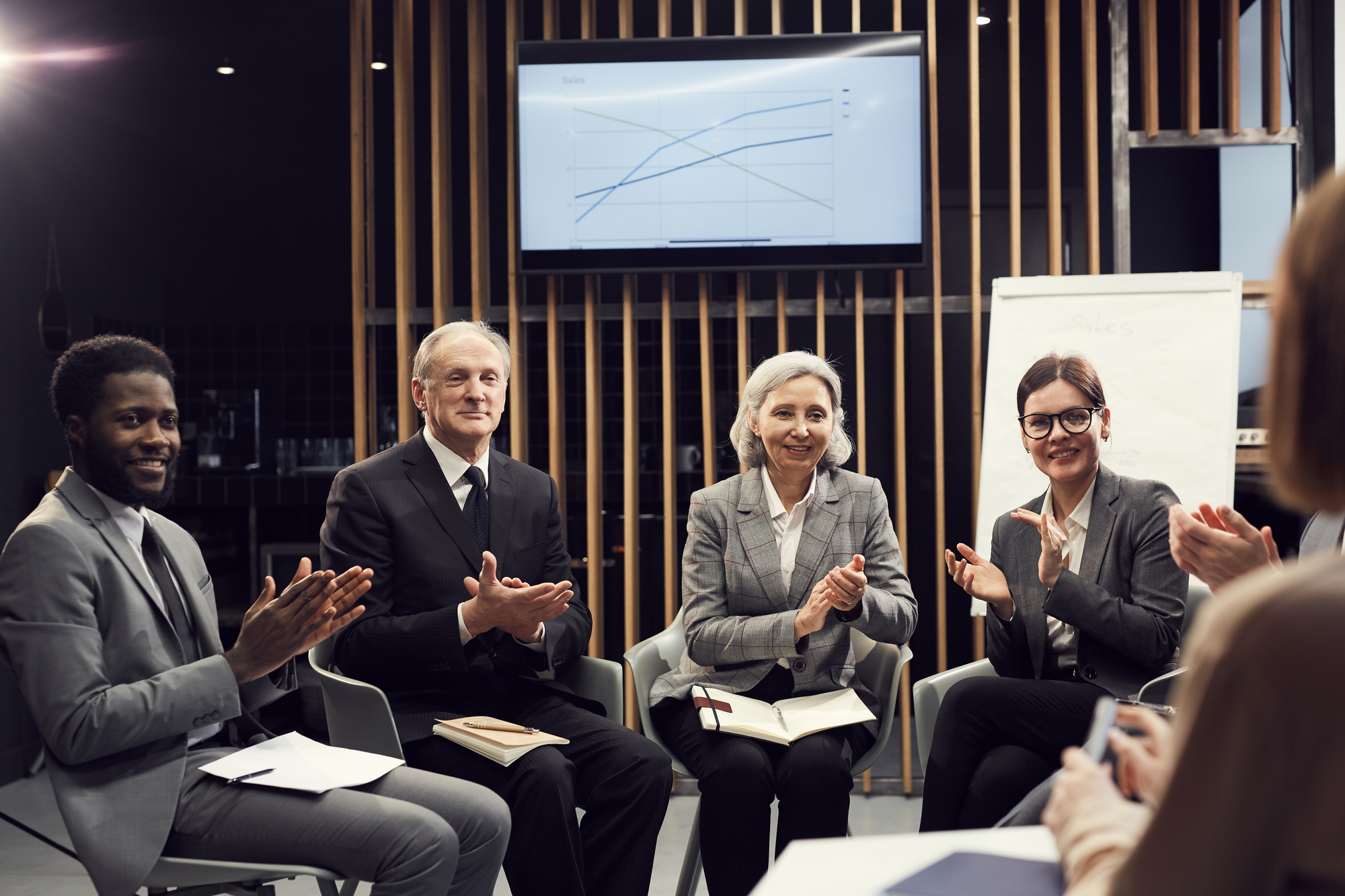 Excited business people applauding sales coach