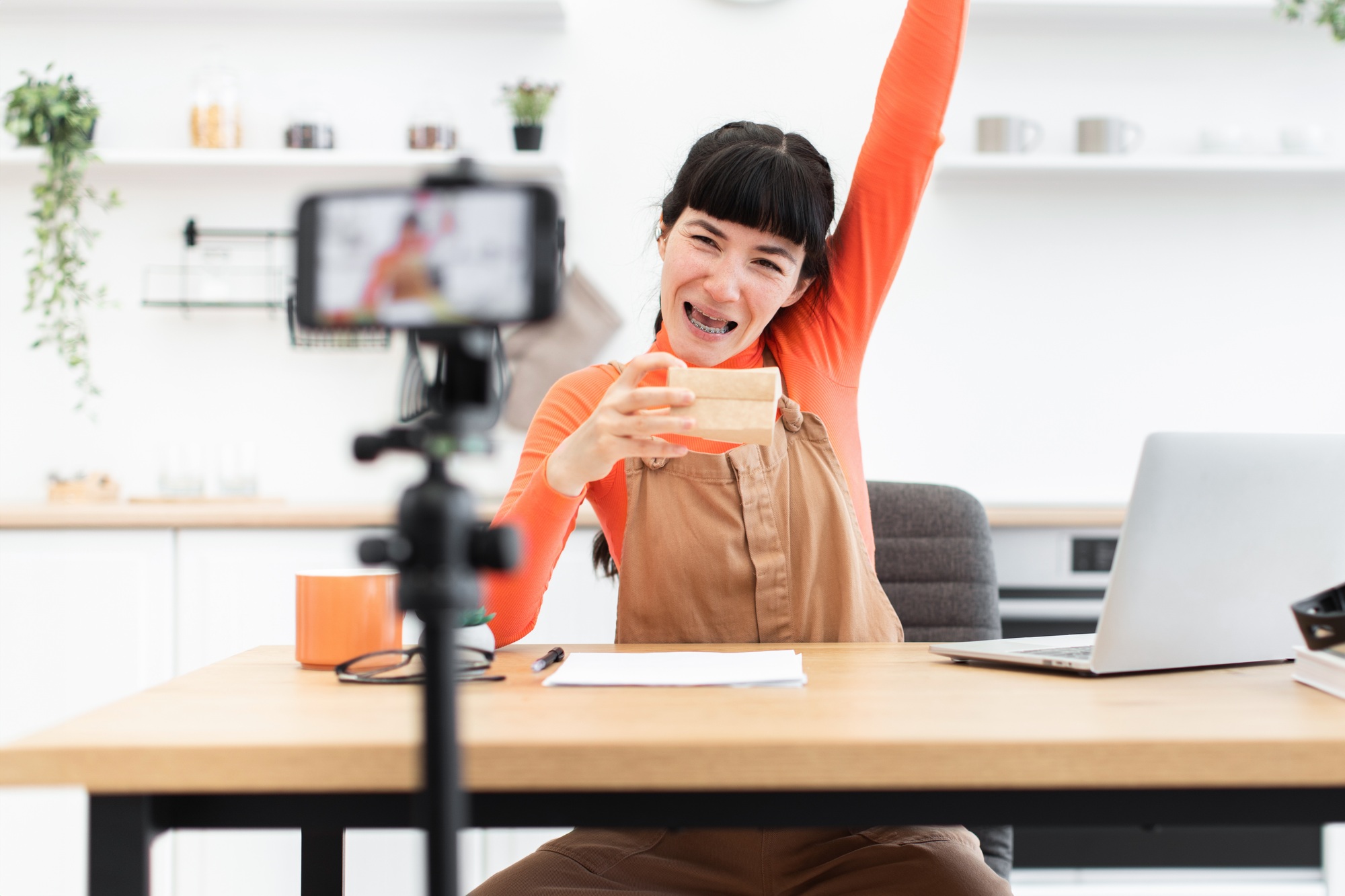 Excited woman filming an unboxing video for her online channel