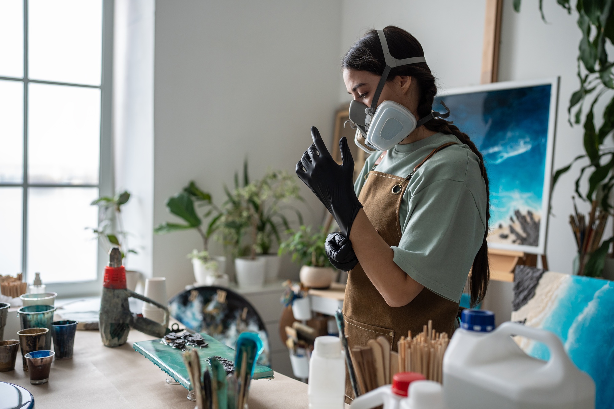 Female artist concentrates, enters state of focus, preparing for hard work on epoxy resin painting.