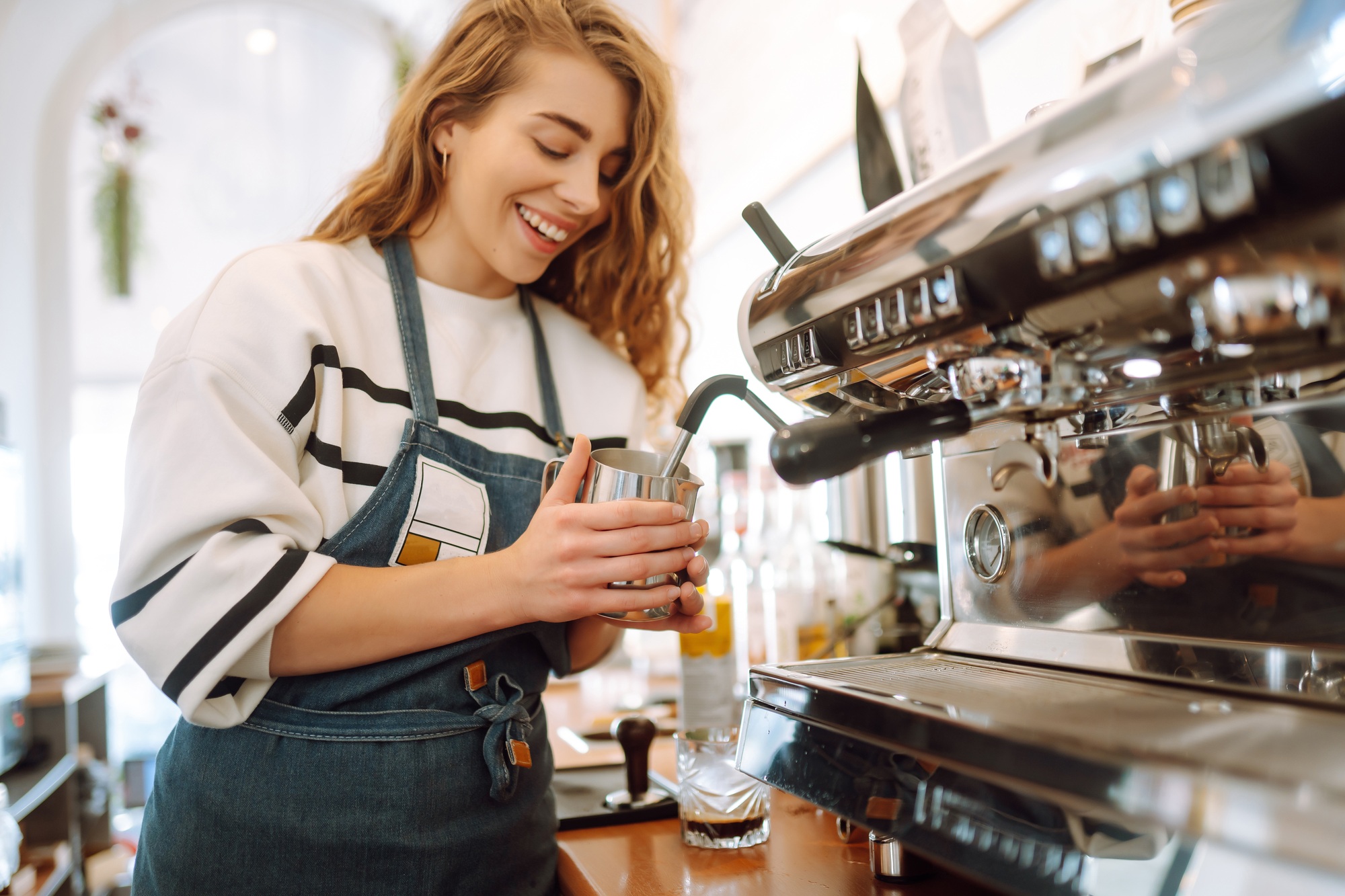 Female barista making coffee in a coffee machine. Conception of business and service. Takeaway food.