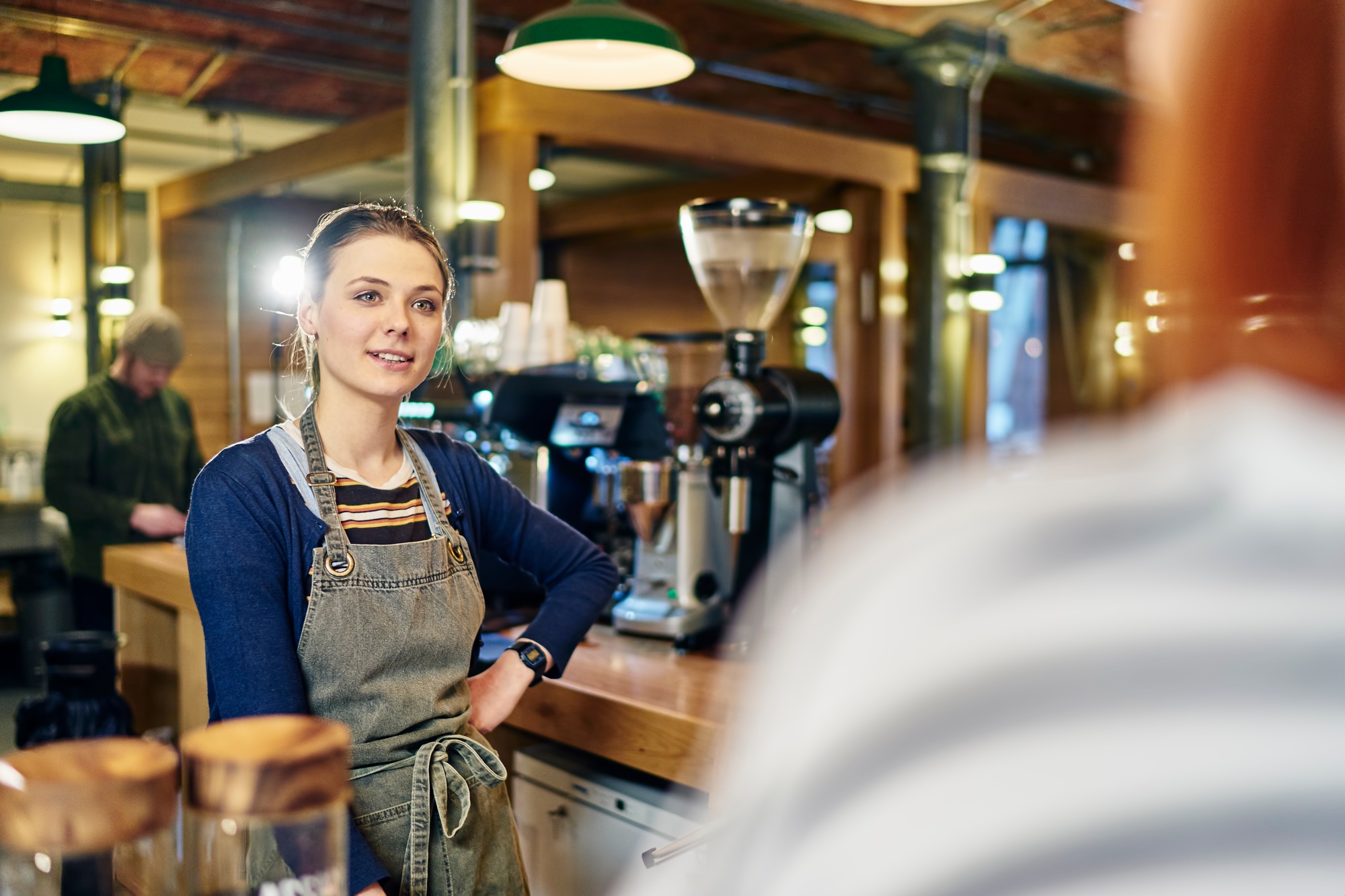 Female barista serving customer in coffee shop
