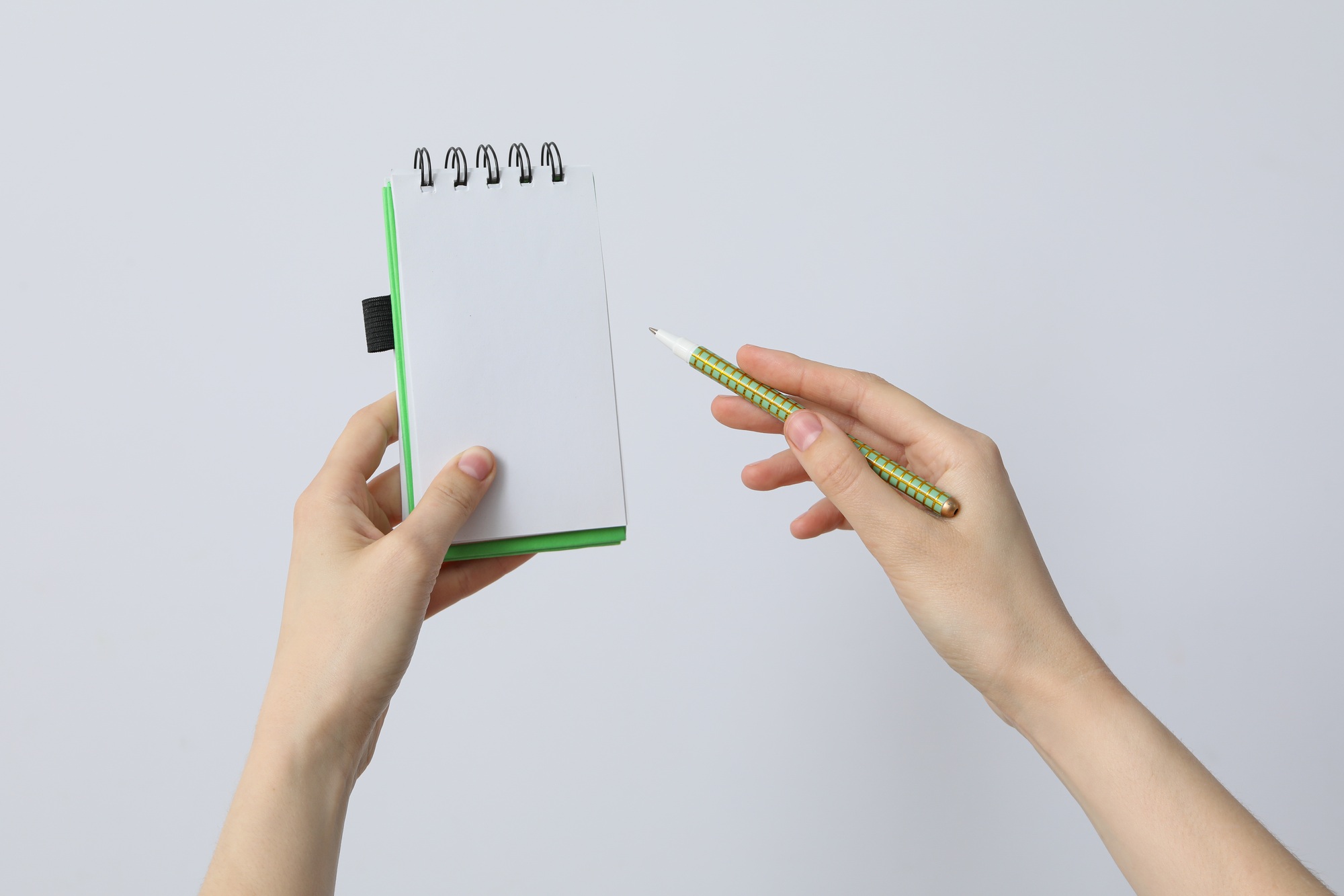 Female hands hold a notebook and a felt-tip pen