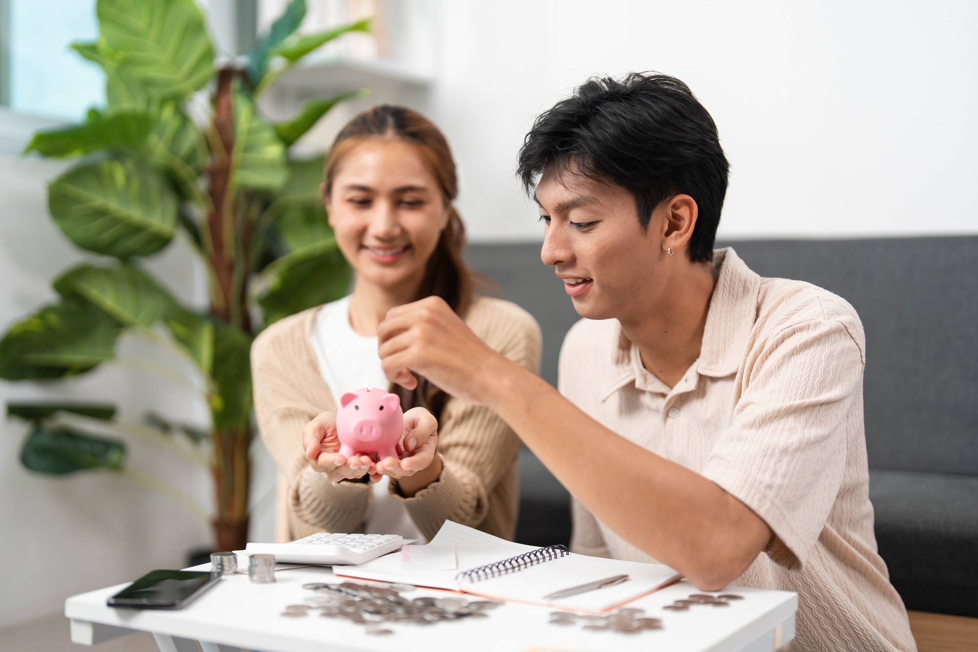 Financial Planning and Budgeting. Young couple managing savings with a piggy bank.