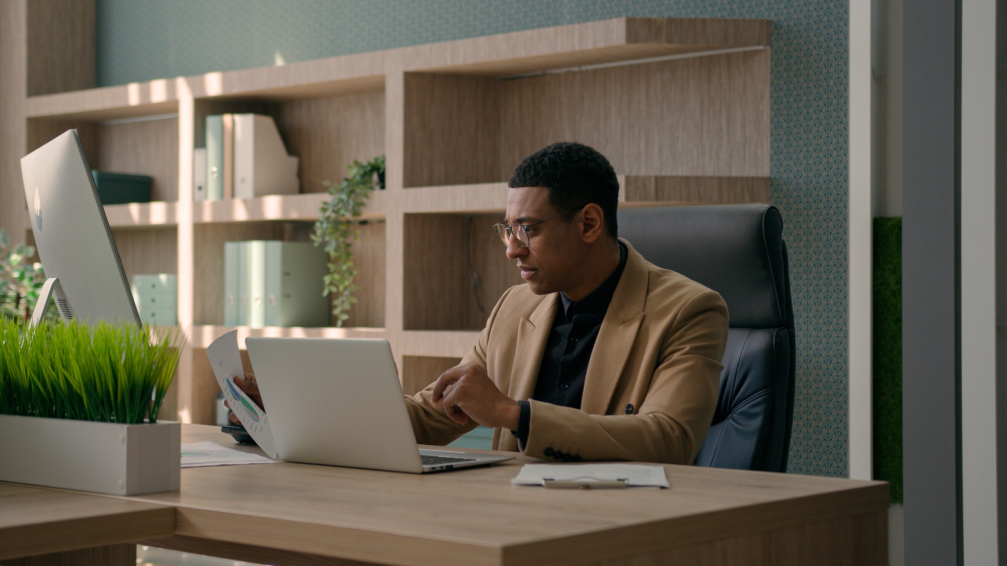Focused African American man businessman working with corporate documents sales research