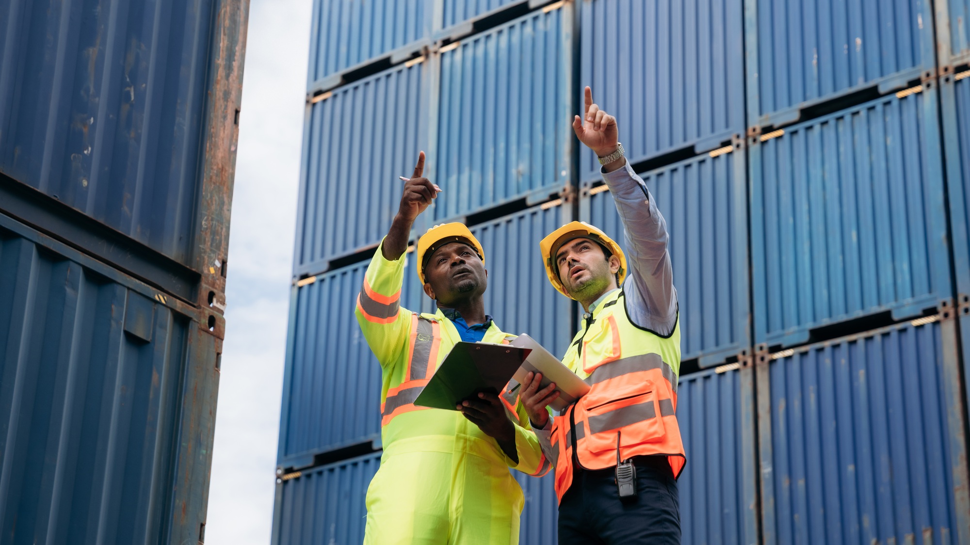 Foreman checking inventory or task details at Container cargo harbor.