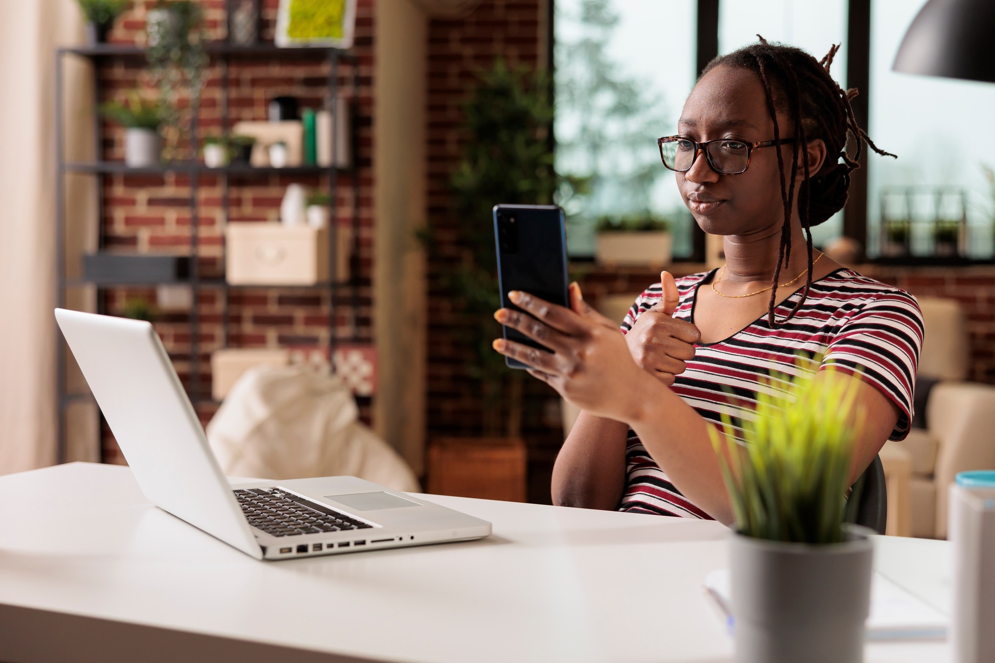 Freelancer showing appreciation gesture on smartphone videocall