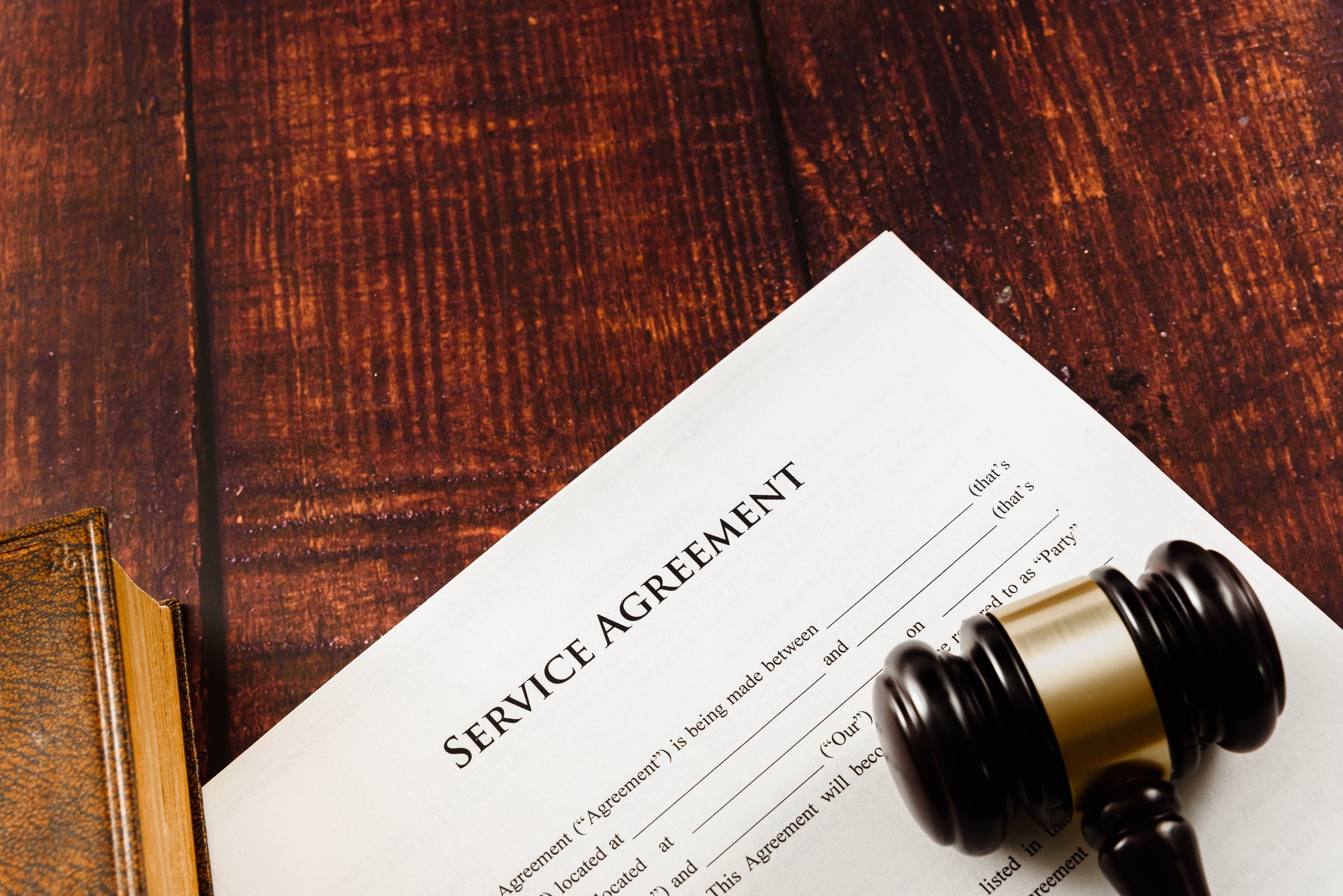 Gavel on the law books that regulate paper contracts to do business.