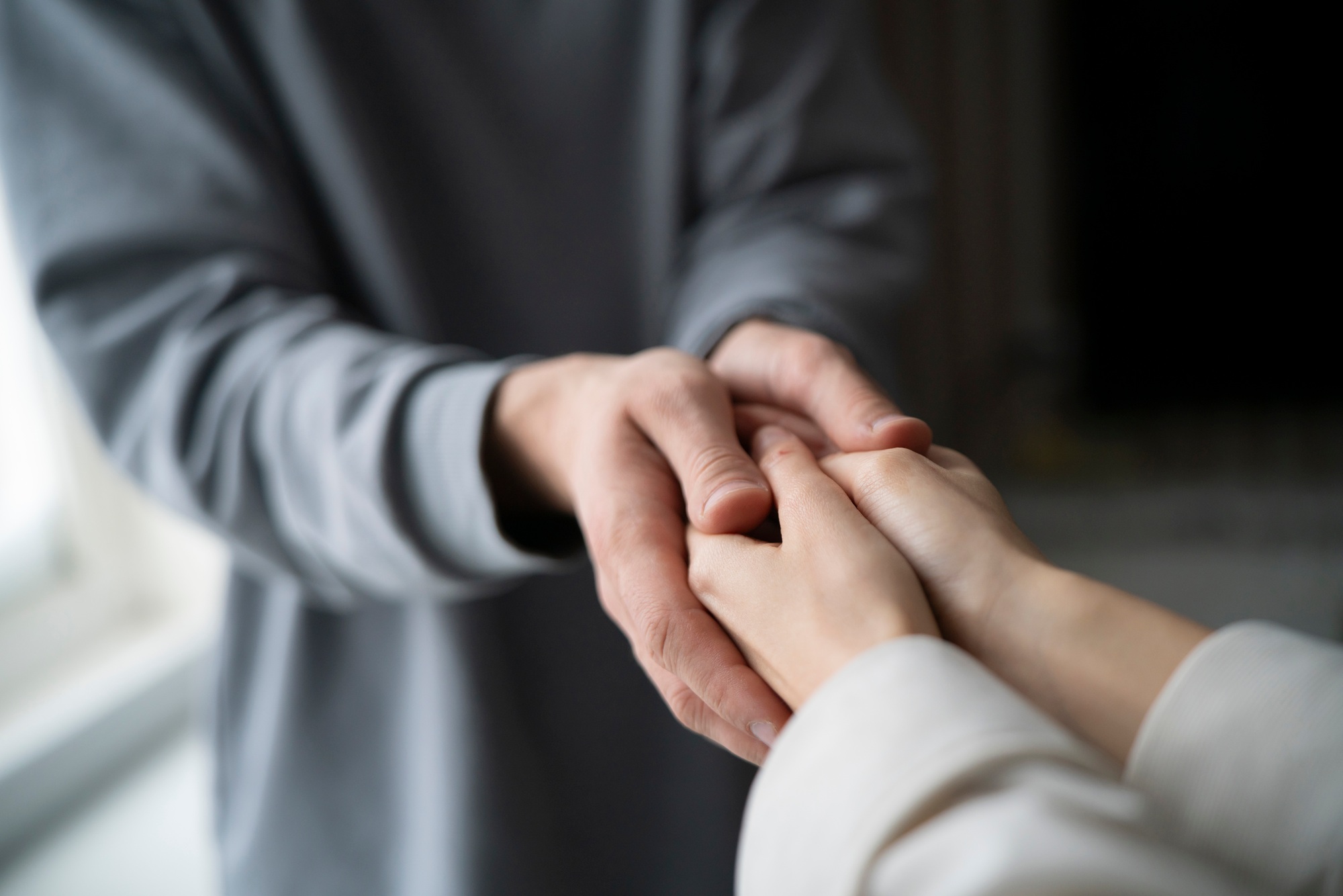 Gentle Male and Female Hands Offering Comfort and Support in a Time of Need