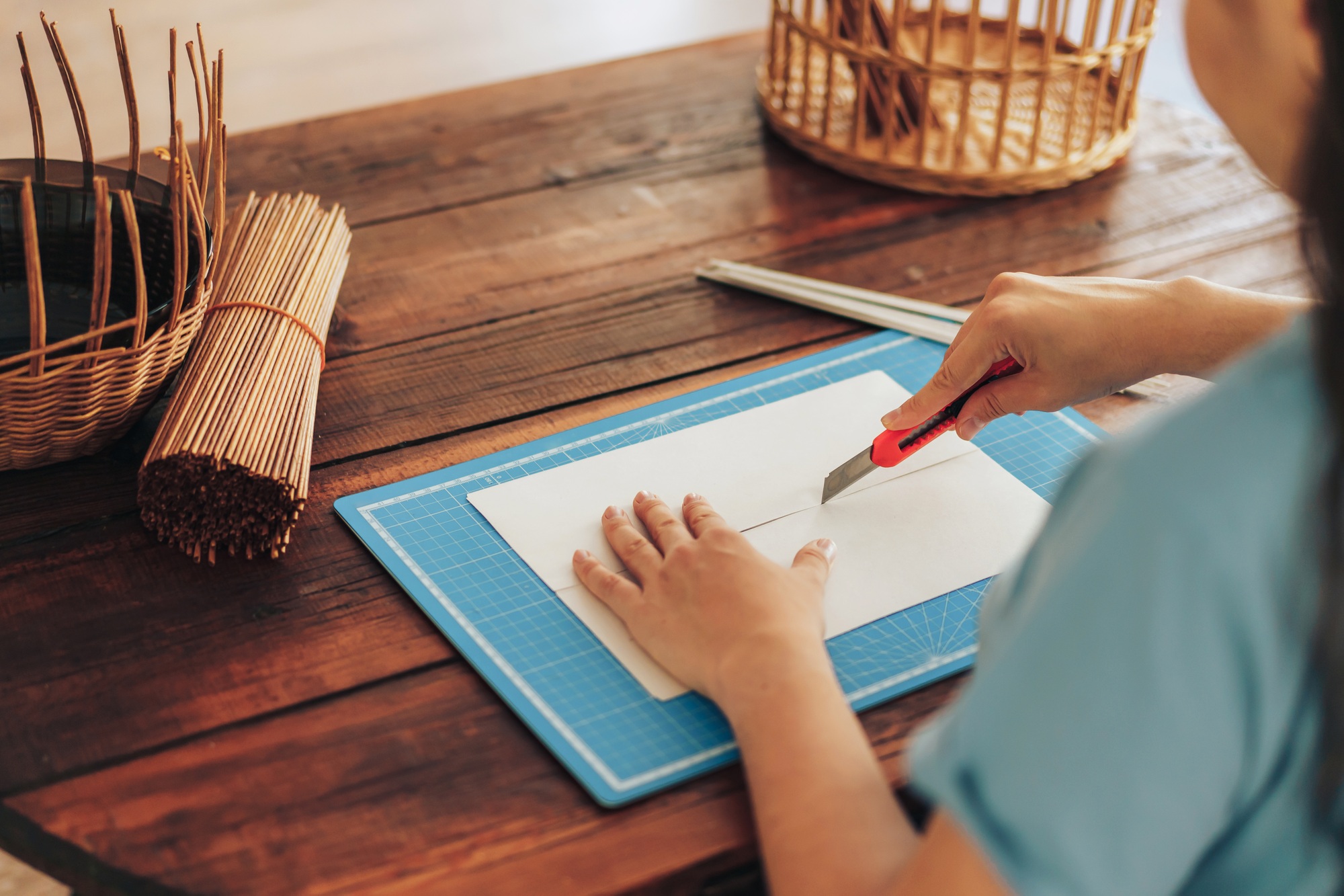 Girl cuts paper in half with stationery knife