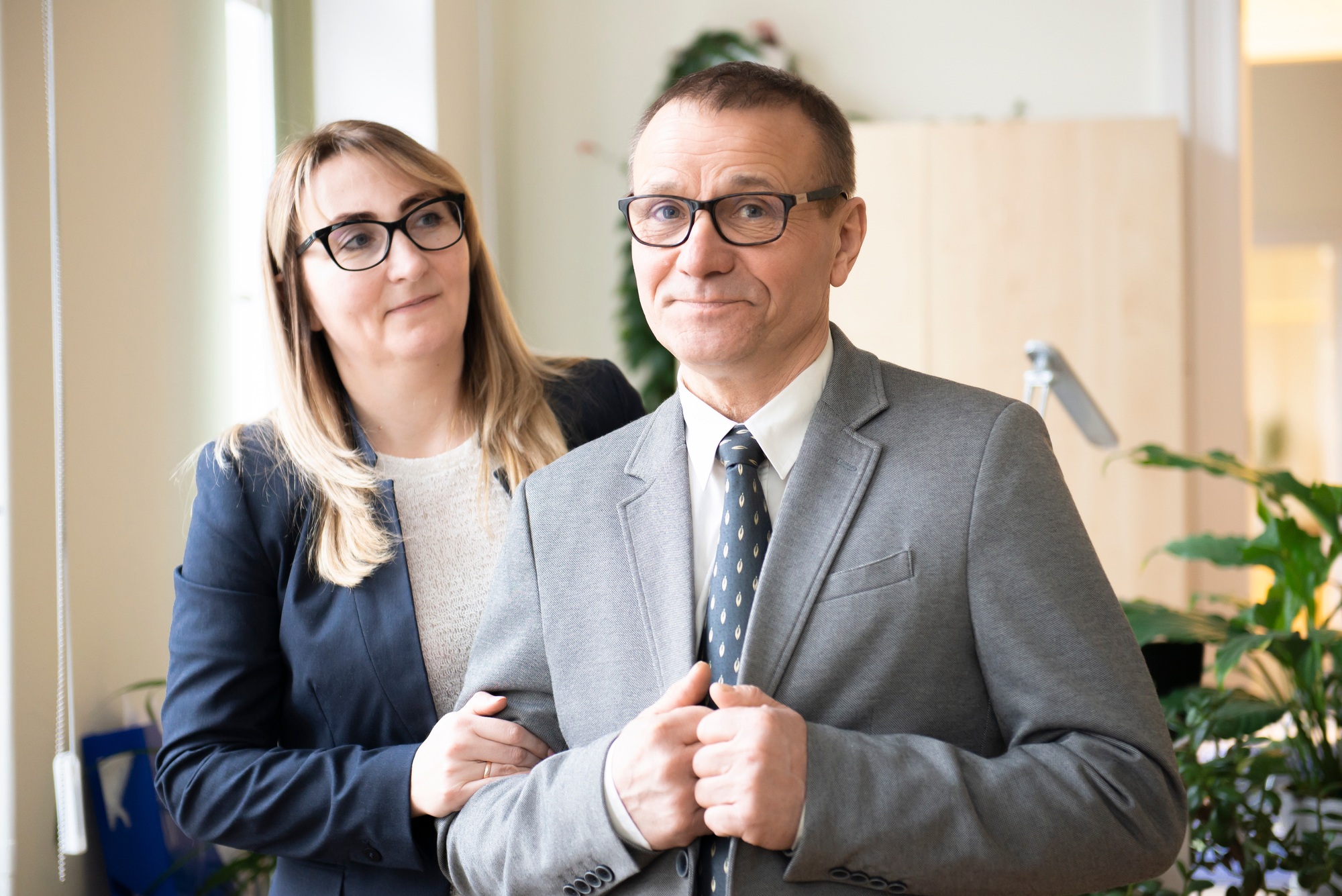 Good looking middle-aged business man and woman couple smiling at camera