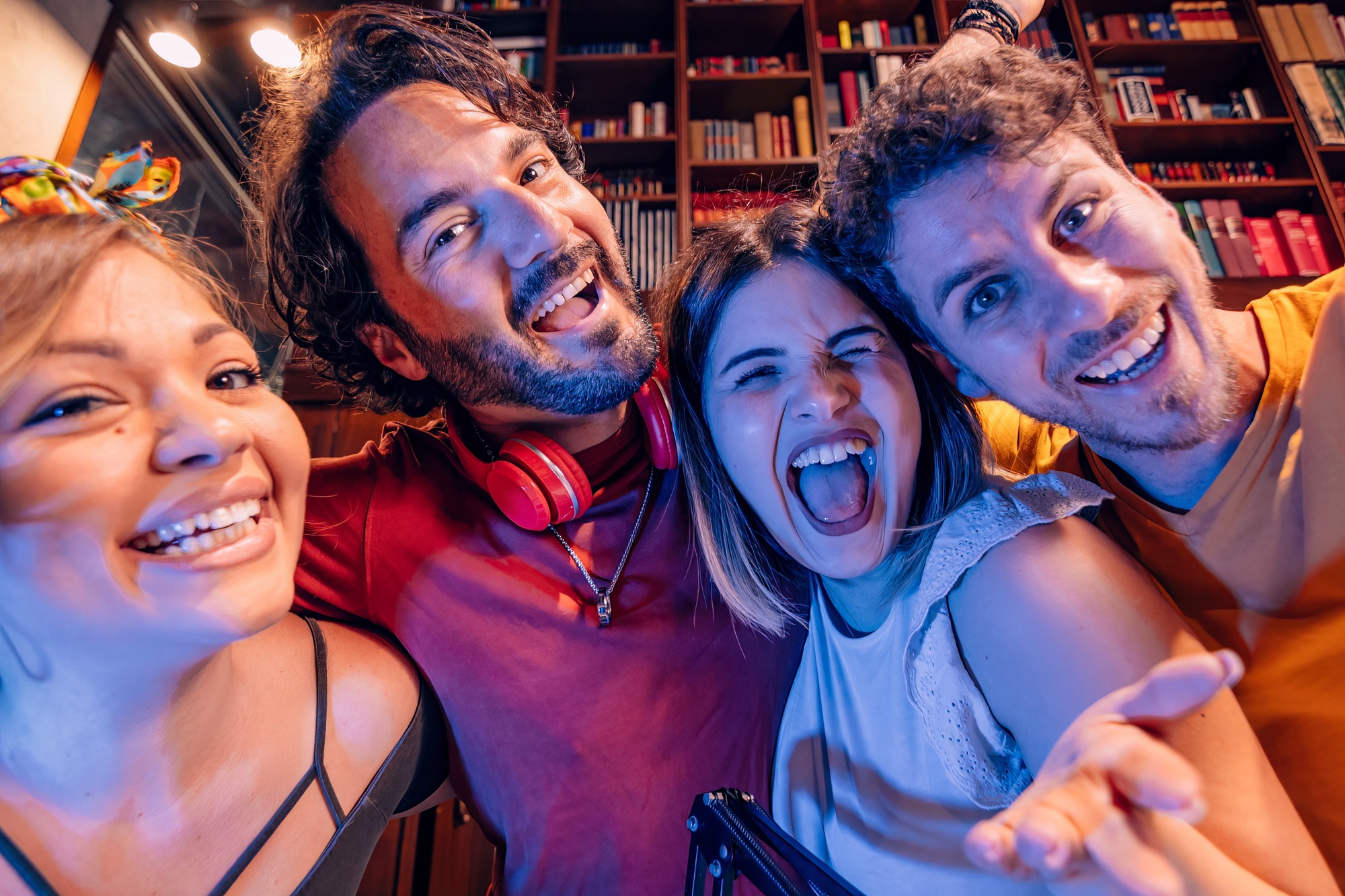Group of friends having fun recording a podcast or video content in home studio