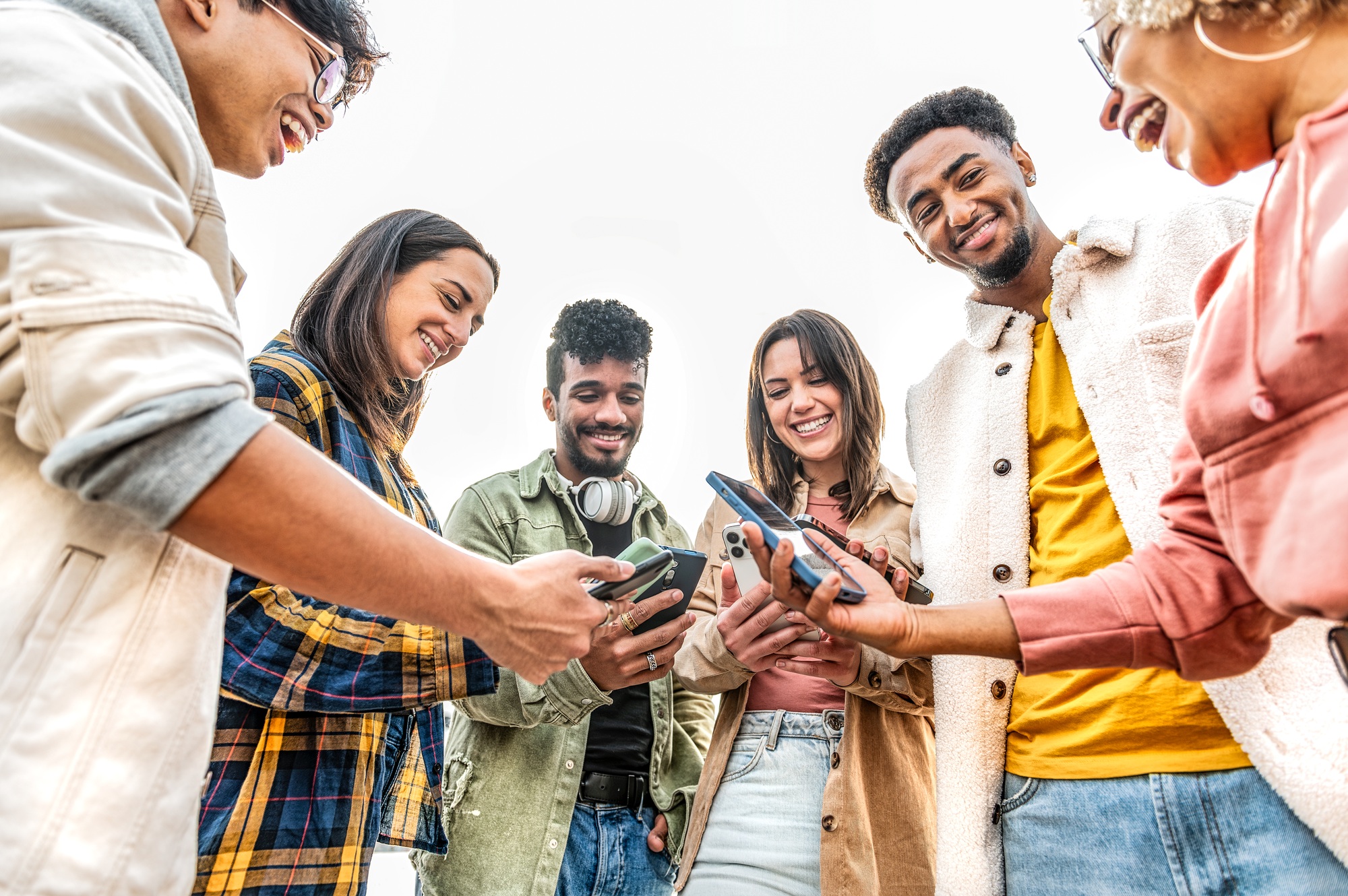 Group of friends watching cellphones sharing content on social media platform