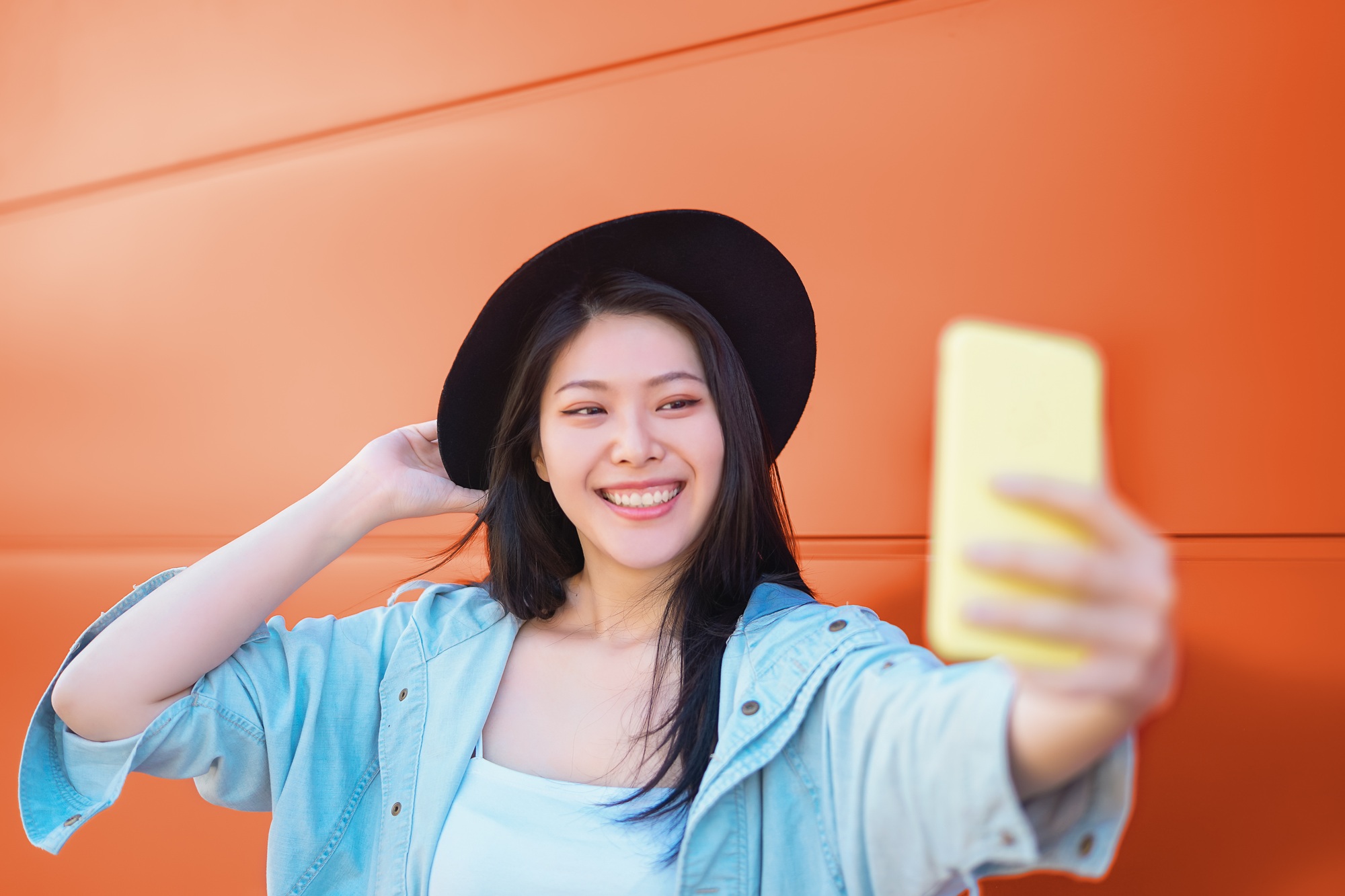 Happy Asian girl taking selfie with mobile smart phone outdoor