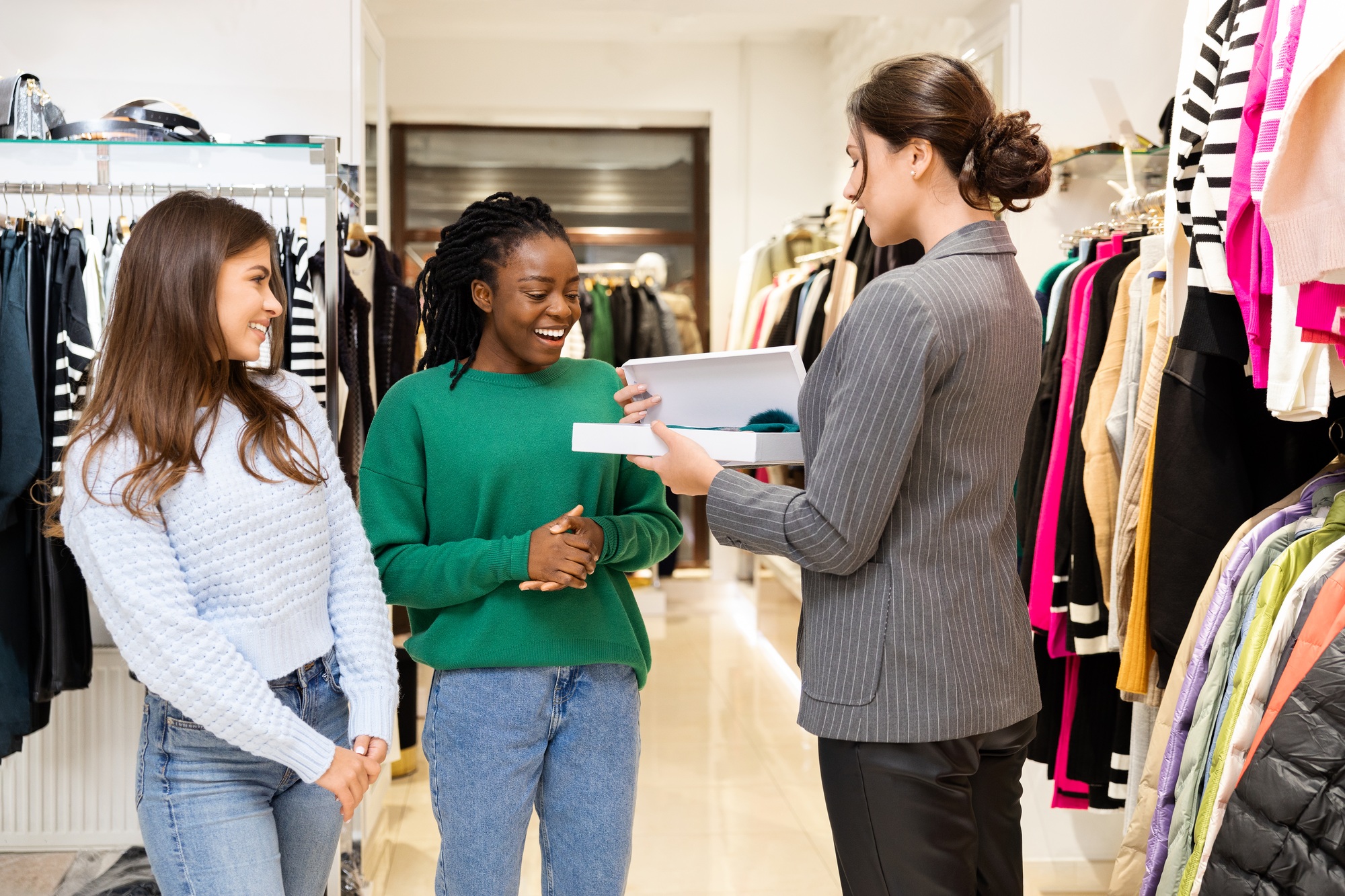 Happy Customers Shopping at Clothing Store with Salesperson