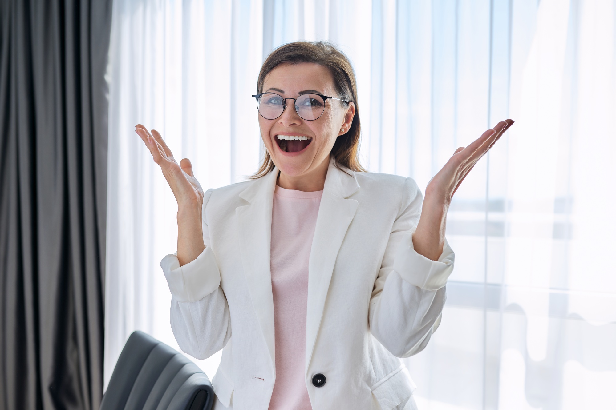 Happy emotional business woman looking at camera in office