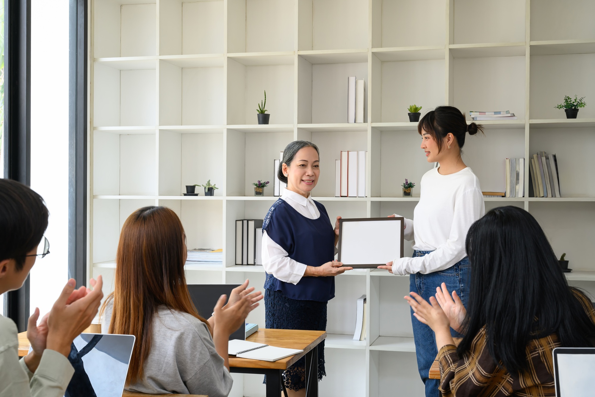 Happy student woman accepting certificate from her professor. Education concept