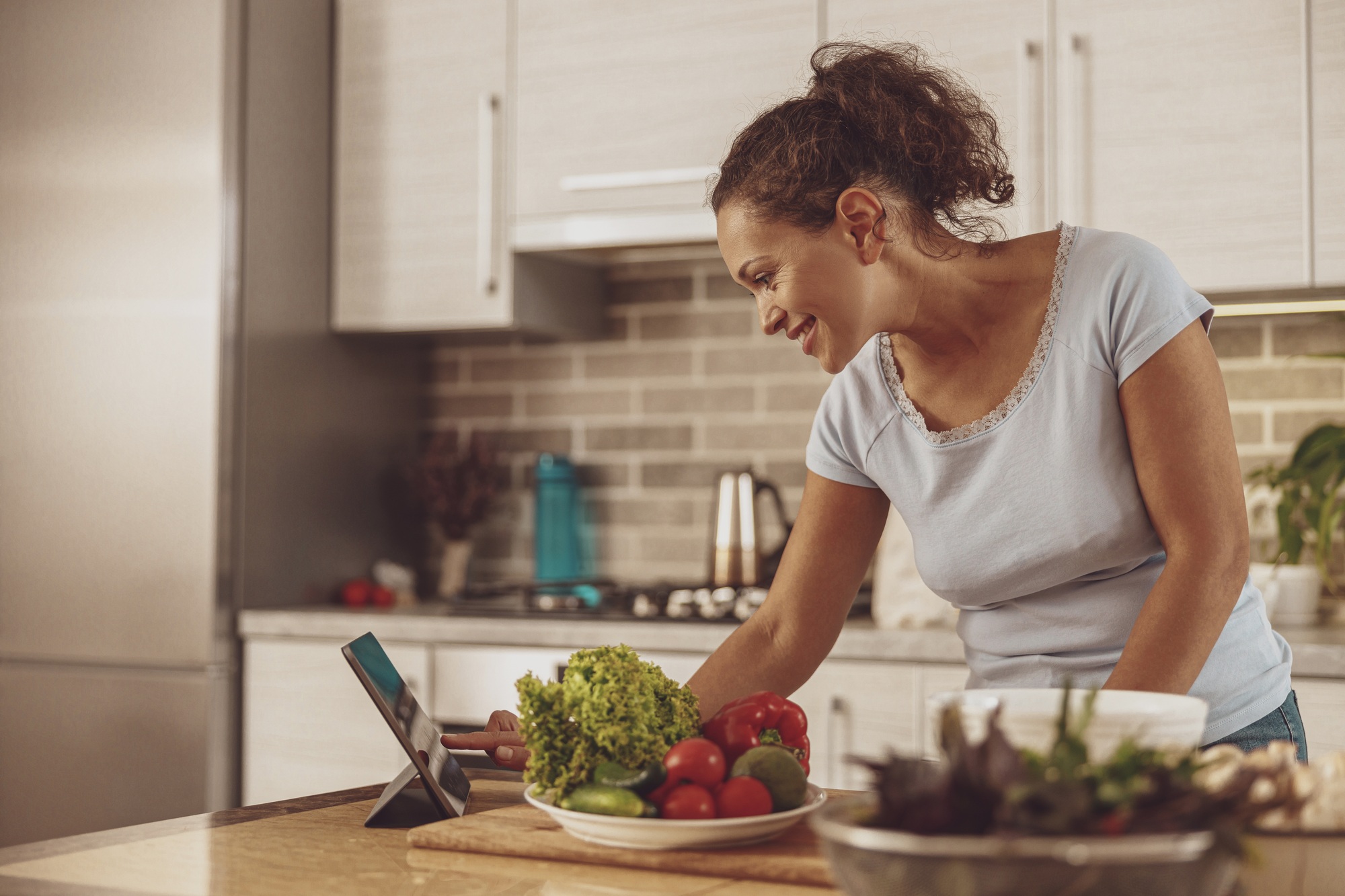 Housewife keeps a video blog about cooking salads standing at the table in the kitchen