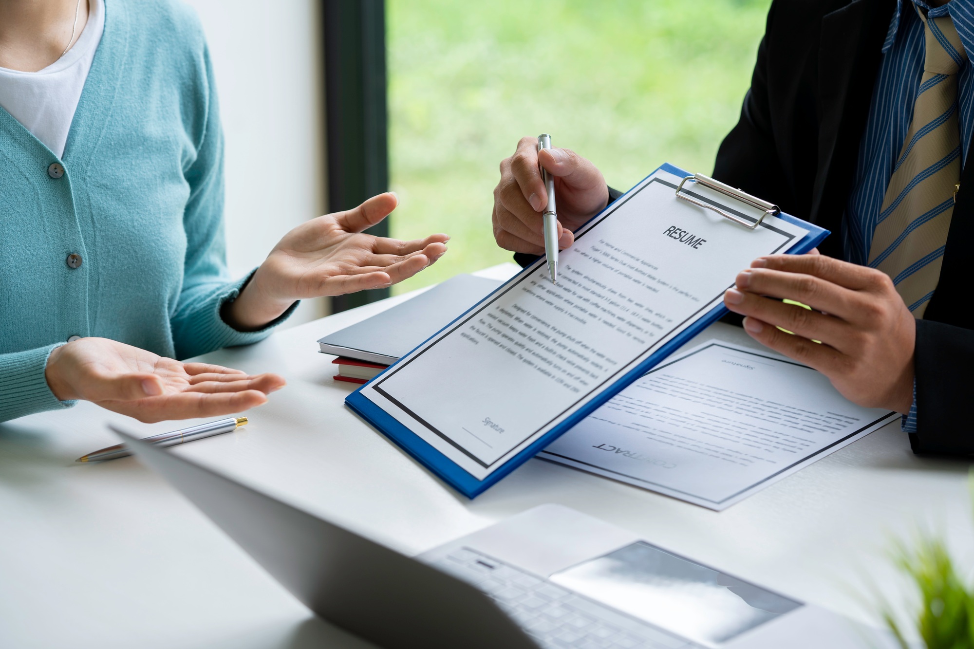 Human resources manager conducting job interview with applicant in the office, Candidate with resume
